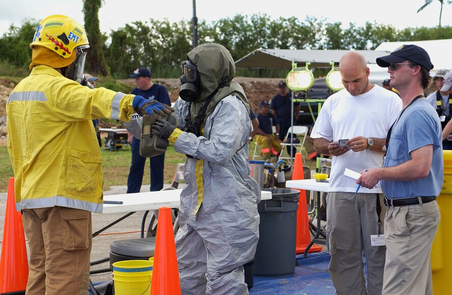 Observers evaluate the decontamination process after a simulated dirty bomb exploded as part of the Topoff 4 Exercise being conducted from 15-19 October. Topoff 4, (T4), is a Congressionally mandated, terrorism preparedness exercise, involving top officials at every level of government, as well as representatives from the international community and private sector. Sponsored by the Department of Homeland Security (DHS), Topoff 4 is the fourth exercise in the Topoff Exercise series. Each Topoff Exercise involves a two-year cycle of seminars, planning events, and exercises culminating in a full-scale assessment of the nation's capacity to prevent, prepare for, respond to and recover from terrorist attacks involving Weapons of Mass Destruction (WMD). T4 uses a series of exercise activities of increasing complexity, and simulates a terrorist WMD campaign with coordinated RadiologicaL Dispersal Device (RDD), or dirty bomb attacks in the states of Arizona and Oregon, and the U.S. Territory of Guam. (USAF Photo by Senior Airman Sonya Padilla/36th Wing Public Affairs)(Released) 