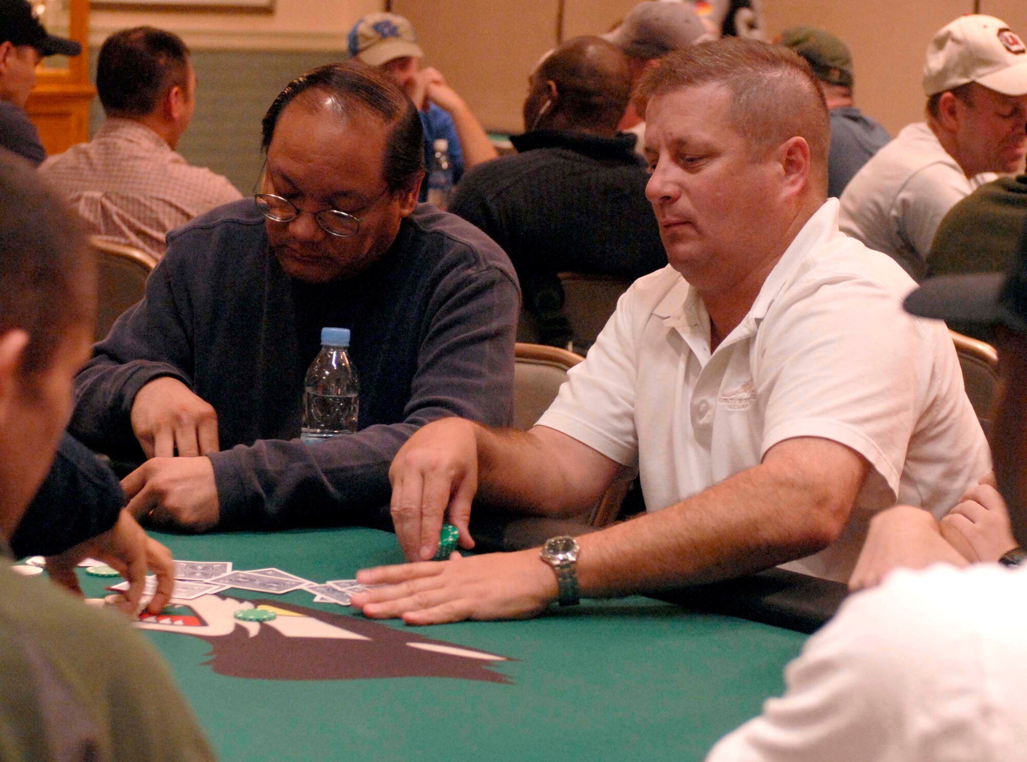 KUNSAN AIR BASE, South Korea - Chief Master Sgt. Robert Britton, 8th Aircraft Maintenance Squadron superintendent, gathers cards for the next hand during the Texas Hold 'Em tournament here Oct. 16.  The 8th Services Squadron is holding a series of qualifying rounds every other Tuesday evening for the next month to determine the Kunsan AB Texas Hold 'Em Champion.  The Kunsan Champion will win a position at the Texas Hold 'Em Championship Showdown in Honolulu, Hawaii Jan. 23-27 with free airfare and lodging.  (U.S. Air Force photo/Staff Sgt. Darcie L. Ibidapo)
