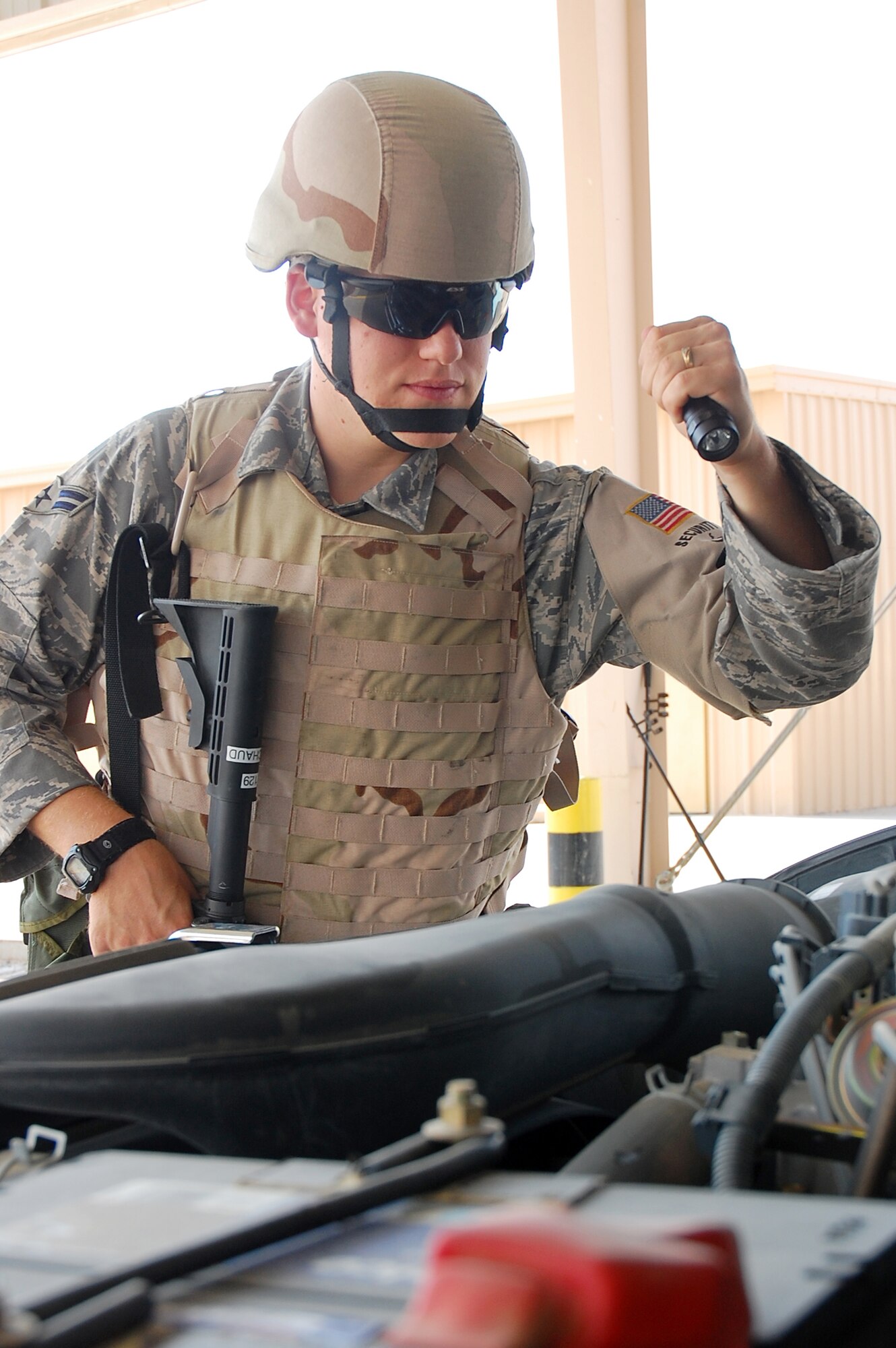 SOUTHWEST ASIA -- Airman 1st Class Christopher Michaud, 386th Expeditionary Security Forces Squadron elite entry controller, performs a security operations check on a vehicle here Oct. 15.  Airman Michaud is from Titusville, Fla., and is deployed from Eglin Air Force Base, Fla.  (U.S. Air Force photo by Staff Sgt. Tia Schroeder)