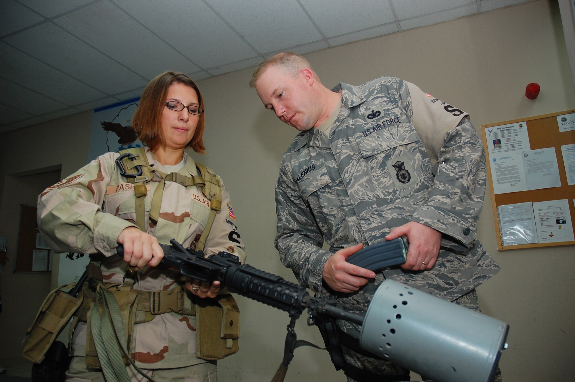 SOUTHWEST ASIA -- Tech. Sgt. Rebecca Pash, 386th Expeditionary Security Forces Squadron plans and programs, performs a clearing check of an M-4 rifle with the assistance from Tech. Sgt. Chris Malenius here Oct. 13.  Sergeant Pash is deployed from Eglin Air Force Base, Fla.  (U.S. Air Force photo by Staff Sgt. Tia Schroeder) 