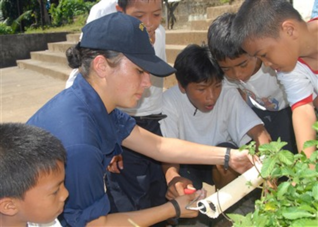 U.S. Navy Seaman Francheska K. Montoya and students from Gordon Heights Elementary School prepare to start painting during a community relations project in Subic Bay, Philippines, on Oct. 16, 2007.  Montoya and other sailors with the USS Tortuga (LSD 46) are participating in bilateral exercises Talon Vision and Amphibious Landing Exercise FY 08 with the armed forces of the Philippines.  