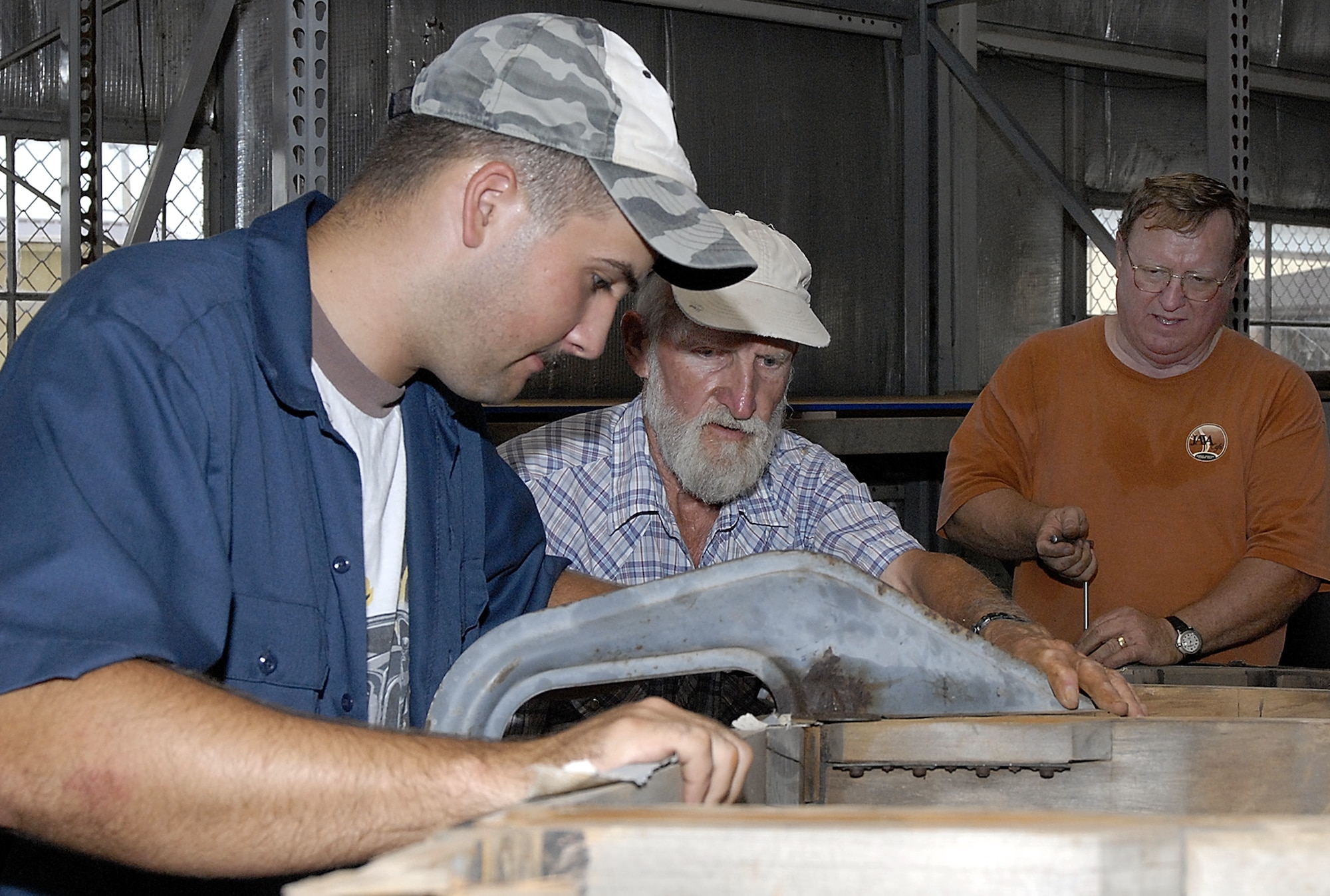 Whiteman Heritage Foundation volunteers Senior Airman Edward Ranowiecki, 509th Munitions Squadron and Knob Noster, Mo., resident Robert Rainey with Frank McKinley (far right), WHF project coordinator, work on a glider-tail assembly as a part of the complete restoration work of a World War II-vintage Waco CG-4A combat assault glider at Whiteman AFB, Mo. The foundation, which  is seeking volunteers to help with the work, plans to display the restored aircraft to highlight that portion of the base's history. During the  1940s, Whiteman AFB, then Sedalia Air Field, served as a base for pilots training to fly the glider.   (US Air Force photo/Master Sgt. Bill Huntington)