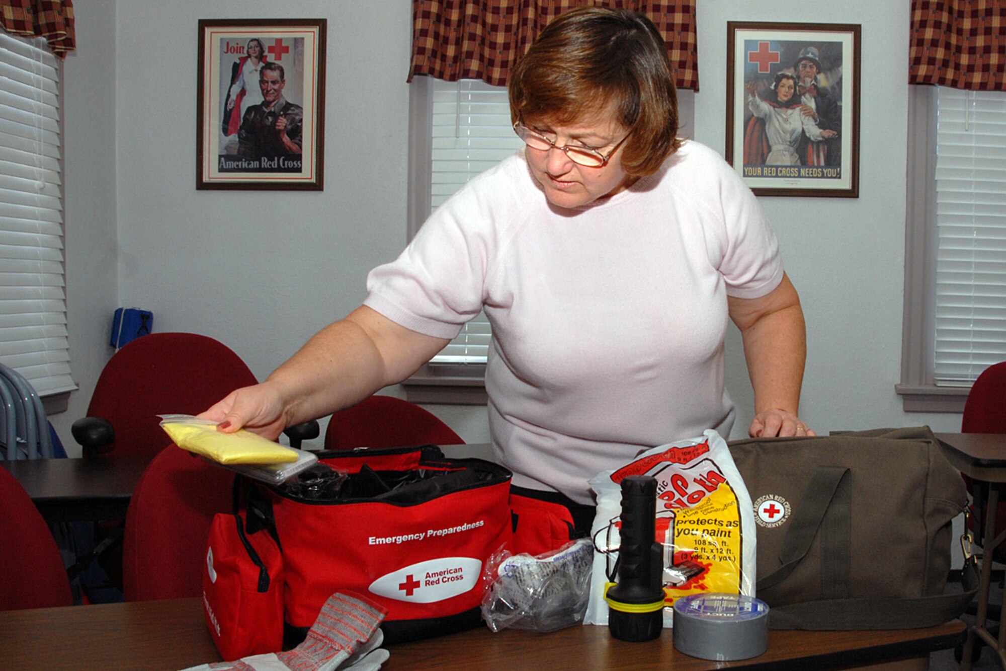 Barb Gilstrap, Red Cross summer youth coordinator, checks an emergency preparedness and disaster bag inventory check. The American Red Cross and its volunteers support the Joint Total Force Scott team in numerous ways.