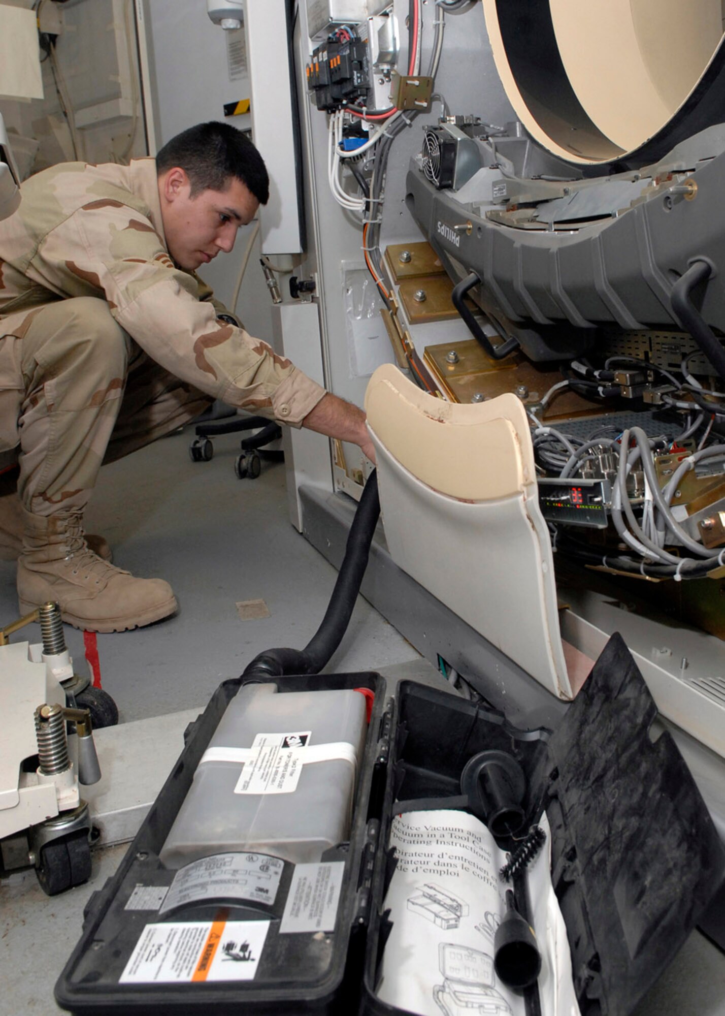Senior Airman Bobby Flores cleans the filters of a CAT scanner Oct. 18 in the Air Force Theater Hospital at Balad Air Base, Iraq. The filters are cleaned monthly to ensure the machine performs optimally. Airman Flores is currently deployed from Lackland Air Force Base, Texas, to the 332nd Expeditionary Medical Support Squadron. (U.S. Air Force photo/Staff Sgt. Joshua Garcia) 
