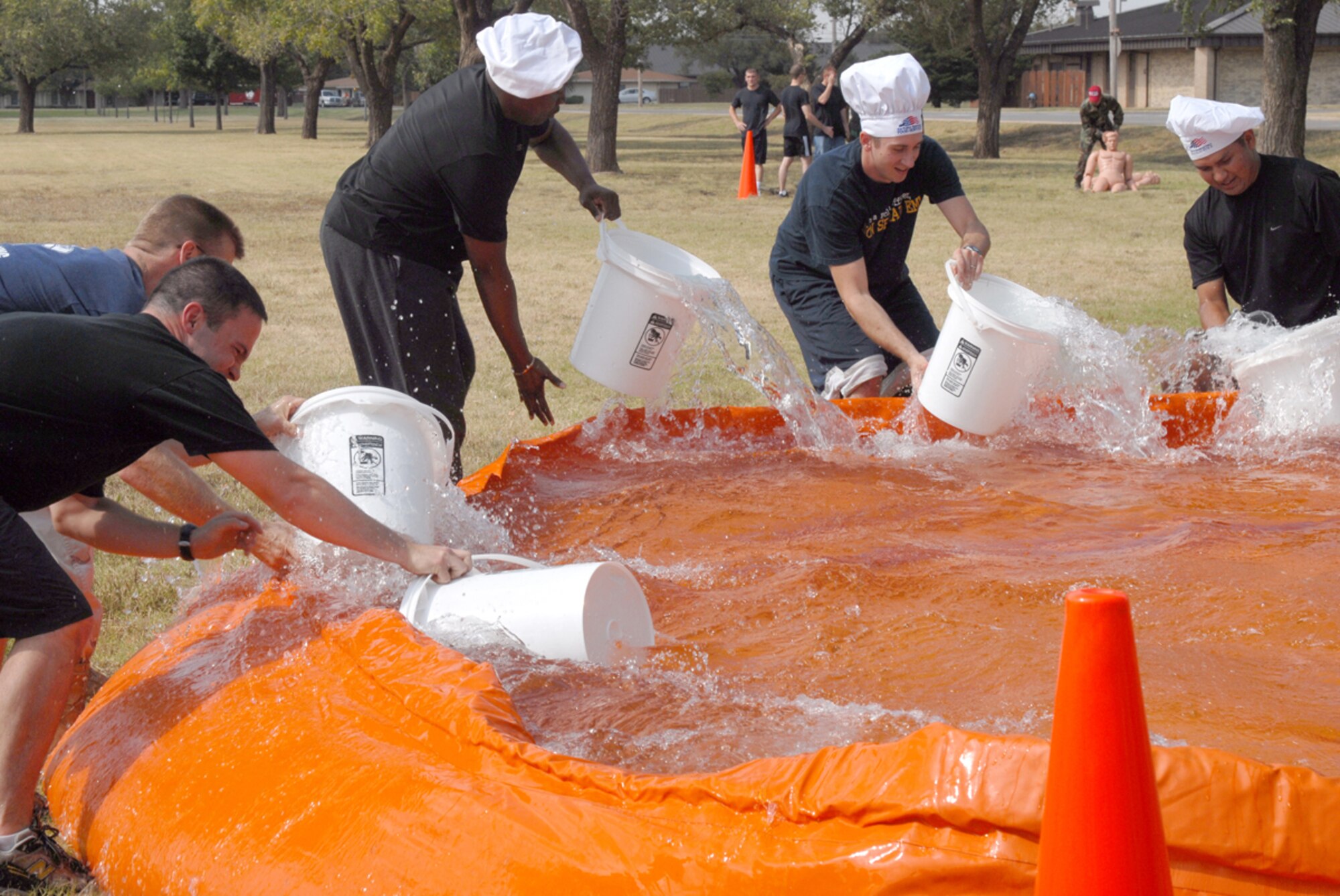 Altus Air Force squadron teams race against the clock to deploy a water hose and knock down a target with a blast of water. The Fire Muster challenged 17 teams in fire-reponse related events ranging from a bucket brigade, donning protective gear, to carrying a manniquin through an obstacle. The 97th Logistical Readiness Squadron "Dawgs" were the winners with the losest compiled times in the various events. Altus Air Force Base also observed Fire Safety Week with a parade of emergency response vehicles from the base and surrounding communities followed by an open house at the base fire station.
(Air Force photo/Amn. Rebecca Talley)
