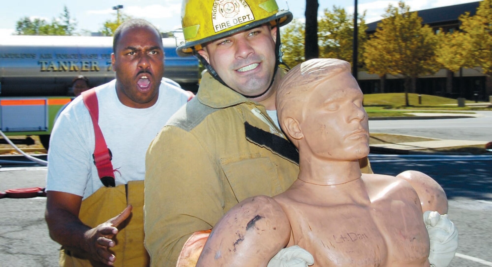 Staff Sgt. Melvin Hill, left, encourages Senior Airman Matthew Sammataro to do his best during the dummy drag portion of the Fire Fighter Challenge Oct. 12. (US Air Force/Bobby Jones)