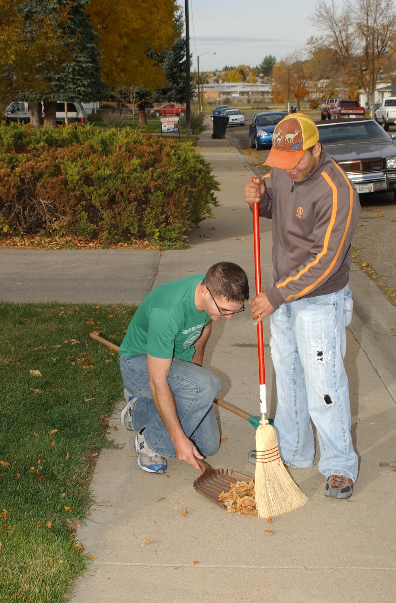 Senior Airman Chris Stephens and Airman 1st Class Andrew Perez, 341st Tactical Response Force, sweet leaves from the sidewalk during the annual Day of Caring. The Day of Caring is held in support of the Combined Federal Campaign and more than 40 teams from Malmstrom helped at residences throughout the community with jobs around the house and yardwork. (U.S. Air Force photo/Airman 1st Class Dillon White) 