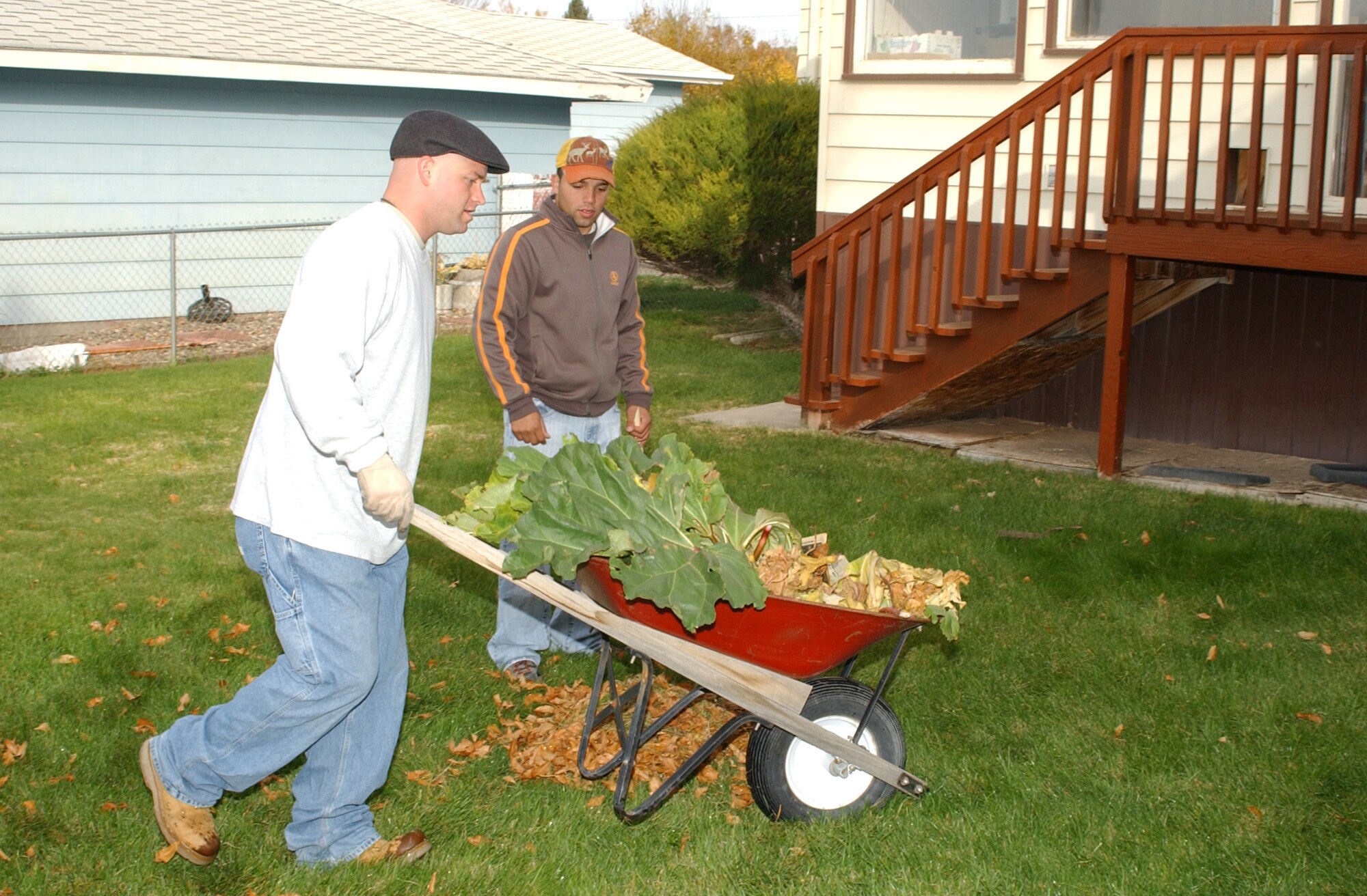 Airman 1st Class Andrew Perez, 341st Tactical Response Force, looks on as Staff Sgt. David Berger wheels away rhubarb plants during the annual Day of Caring. (U.S. Air Force photo/Airman 1st Class Dillon White) 