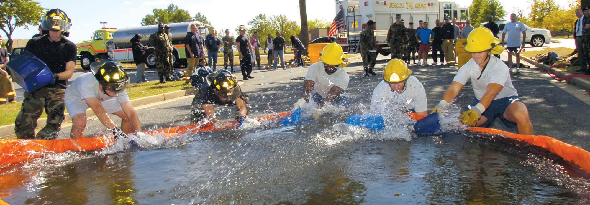 The 79th Medical Wing and 316th Wing Security Forces Squadron Combat Arms Training and Maintenance team members compete in a Bucket Brigade competition during the Annual Fire Fighters Challenge Oct. 12. The challenge competition concluded a week-long observation of National Fire Prevention Week, Oct 7 through oct. 12. The 316 CES sponsors the annual event to educate military members and their families and base population about fire safety. (US Air Force/Bobby Jones)