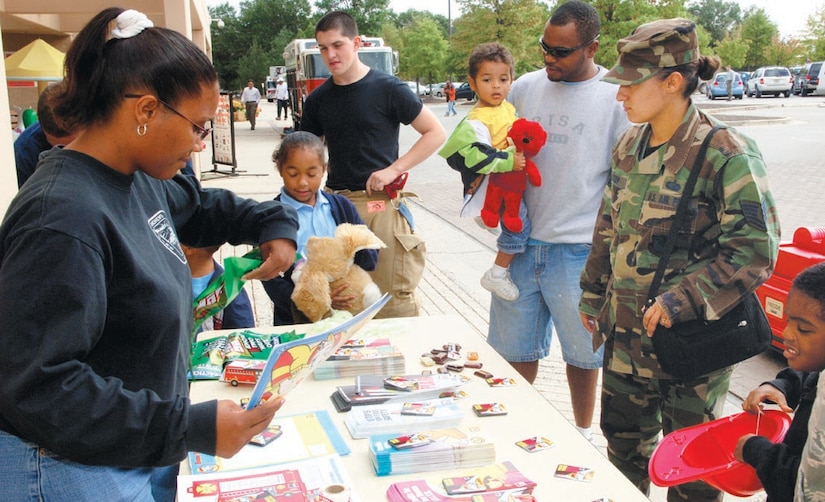 Lori Robinson, left, gives out fire prevention phamplets at the Base Exchange Oct. 11. Lori is the wife of Staff Sgt. Daniel A Robinson, 316th Civil Engineer Squadron lead fire inspector. (US Air Force/A1C Renae Kleckner)