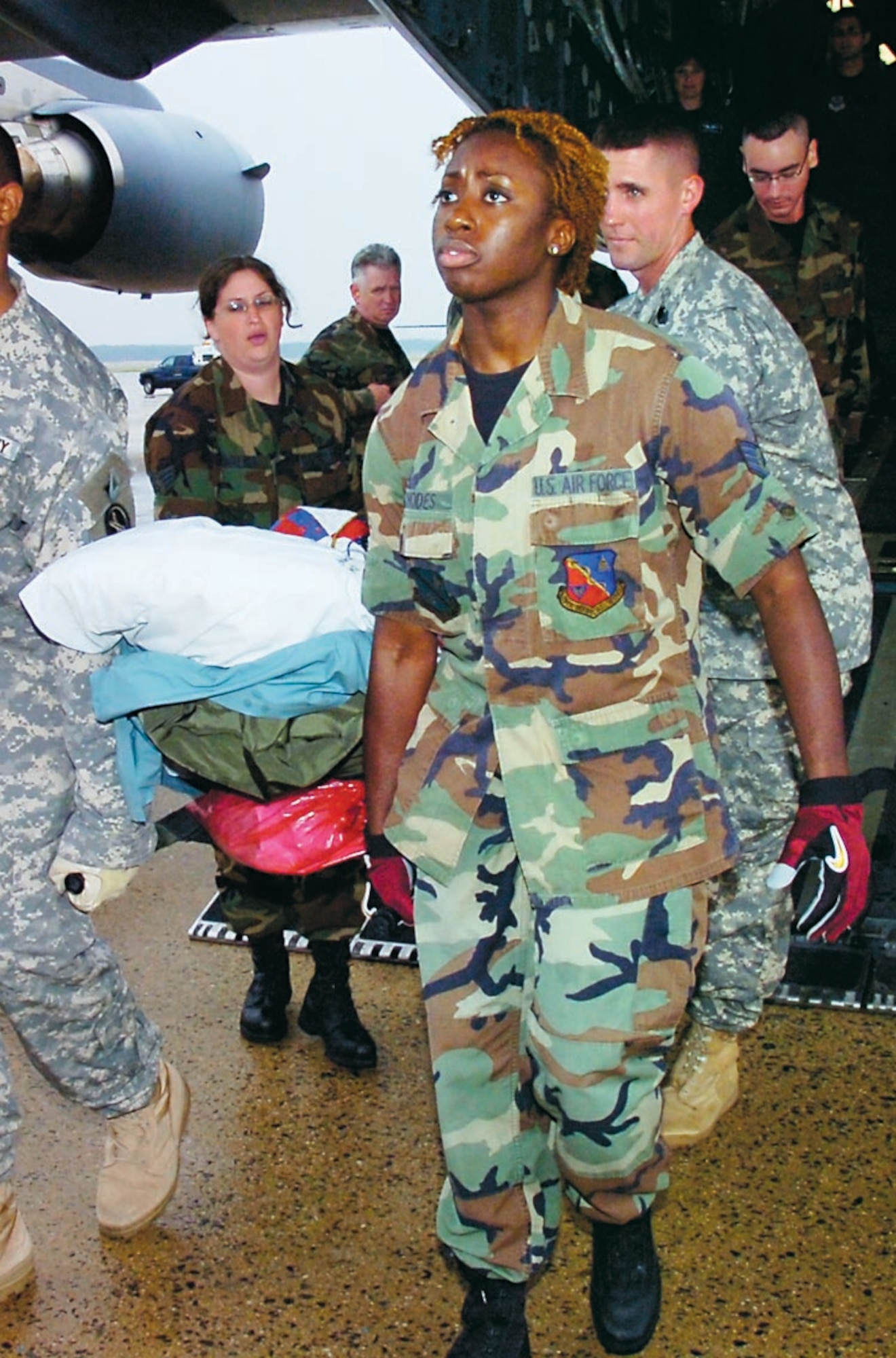 Staff Sgt. Elisha Rhodes, 79th Aerospace Medicine Squadron, helps transport a wounded servicemember from an Air Medical Evacuation flight, July 18. (US Air Force/Bobby Jones)