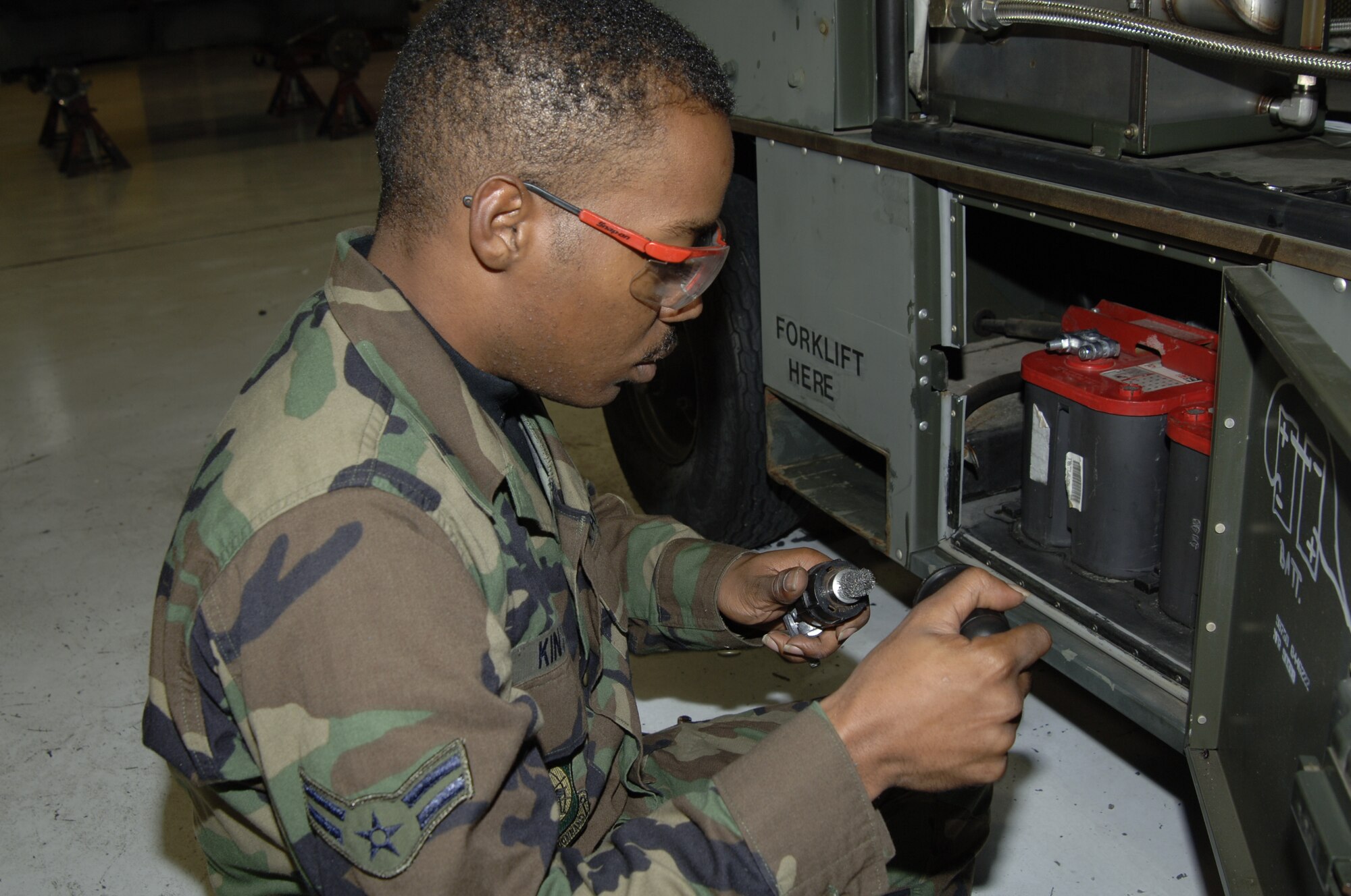 MCCONNELL AIR FORCE BASE, Kan. -- Airman 1st Class Bryan Kinsey, 22 Maintenance Squadron cleans battery terminals on a 95 LASS Oct. 17.  Preventative maintenance helps reduce the corrosion of equipment and sustains operation.  (Photo by Airman 1st Class Roy Lynch III)