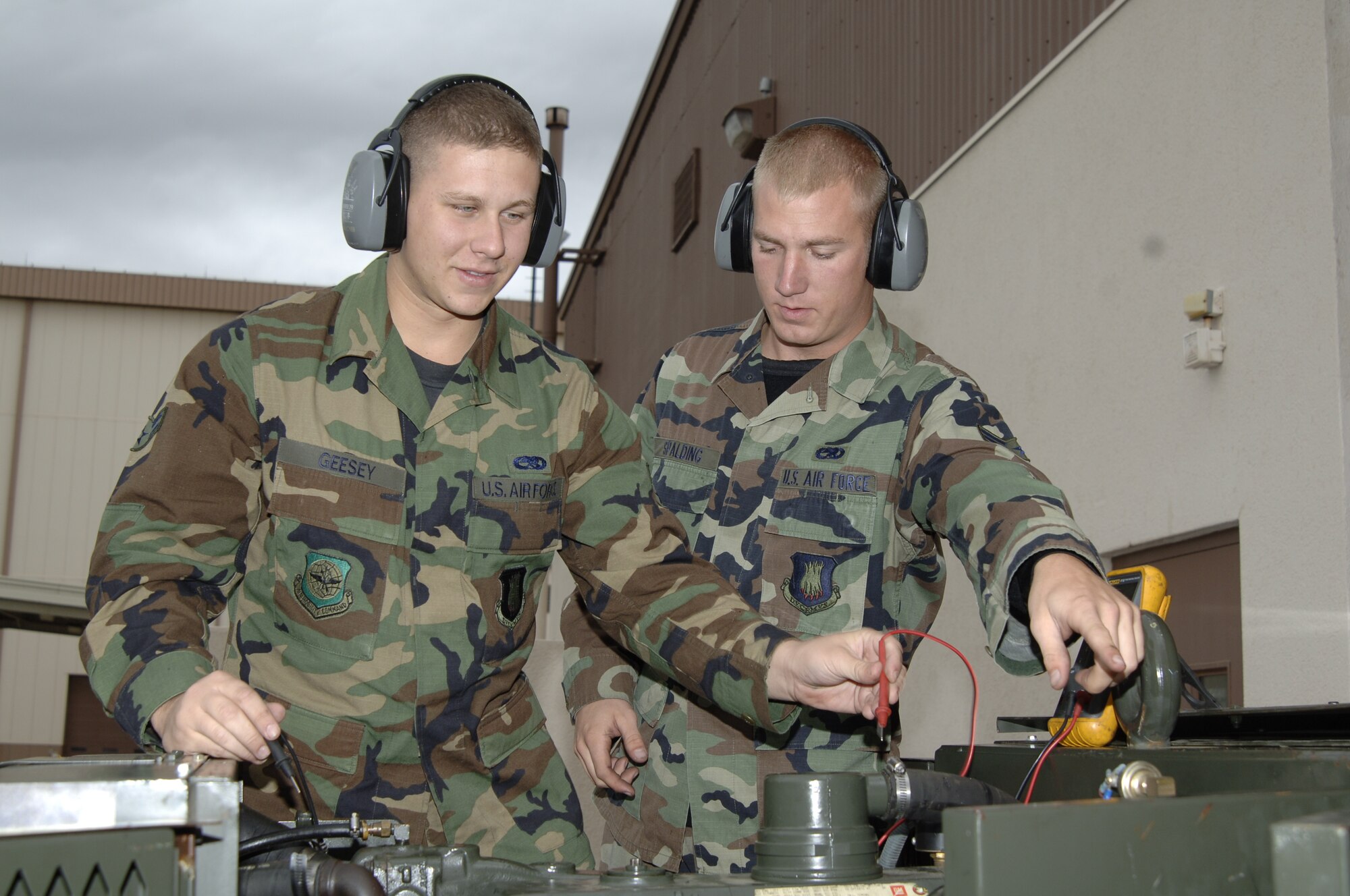 MCCONNELL AIR FORCE BASE, Kan. -- Airman 1st Class Justin Geesey, left and Kevin Spalding, 22 Maintenance Squadron, check the electrical current, utilizing a digital multi-meter, on a Hobart -86 Generator Oct. 17.  (Photo by Airman 1st Class Roy Lynch III)   