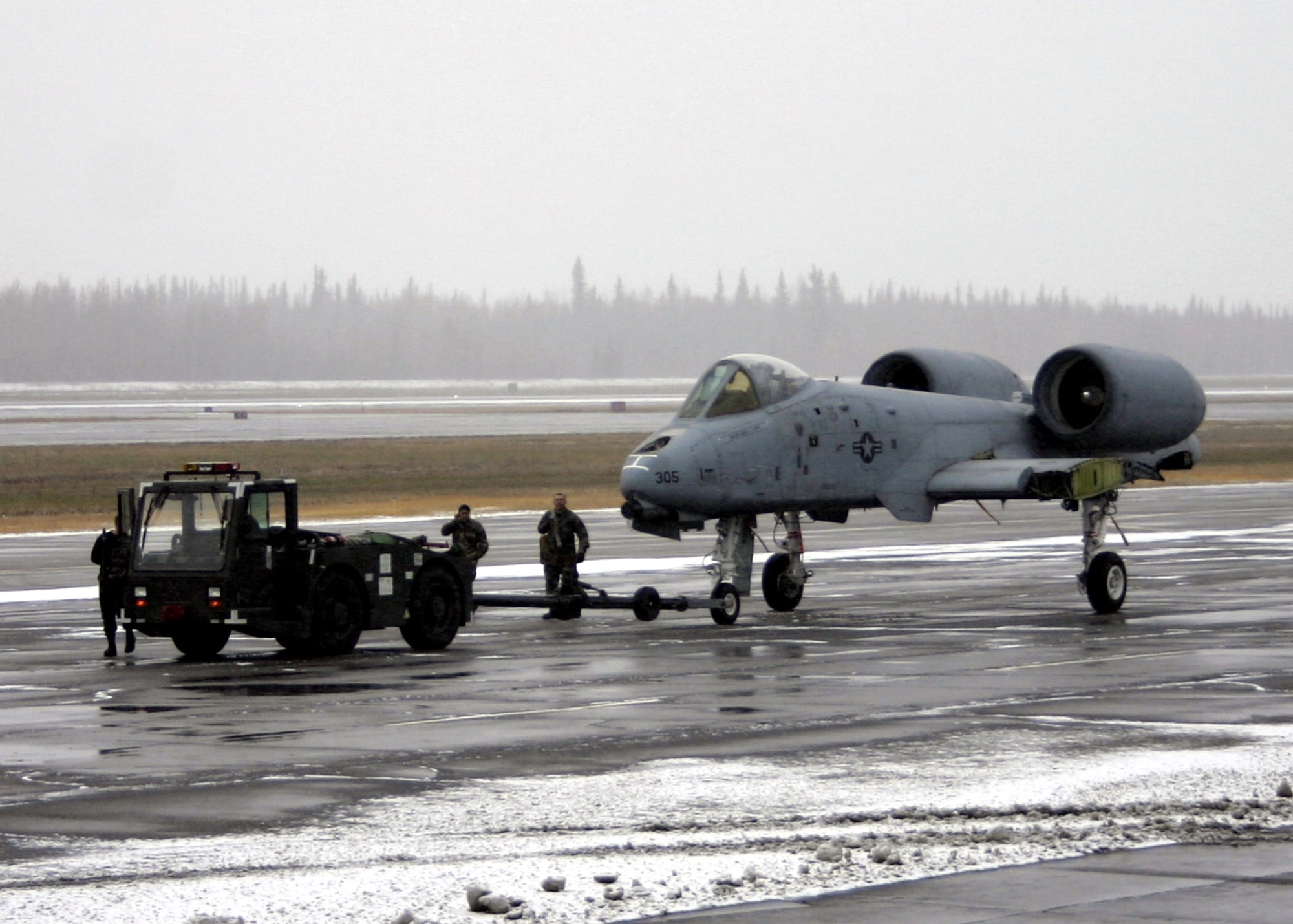 An A-10 Thunderbolt II is towed toward a C-5 Galaxy for transport to the Robins Air Force Base, Ga. Museum of Aviation Flight and Technology Center Oct. 6 at Eielson Air Force Base, Alaska. This is the last assigned A-10 to leave Eielson AFB. The plane was inactivated in 1996 due to the Air Force's need for ground trainers, and has been used for weapons ground training ever since. (U.S. Air Force photo/Staff Sgt. Brian Hibbert) 
