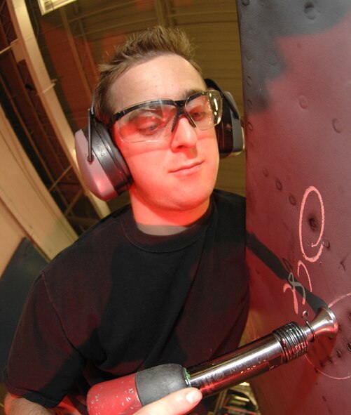 MINOT AIR FORCE BASE, N.D. -- Senior Airman Nathan Courtney, a sheet metal technician for the 5th Maintenance Squadron, shoots rivets into an upper body cowling that protects an aircraft engine Oct. 11. The cowling contains over 200 rivets that hold it together. With Boeing no longer making many parts for B-52H Stratofortresses, the Fabrication Flight of the 5th MXS improvises and creates hand crafted solutions. (U.S. Air Force photo by Senior Airman Christopher Boitz)