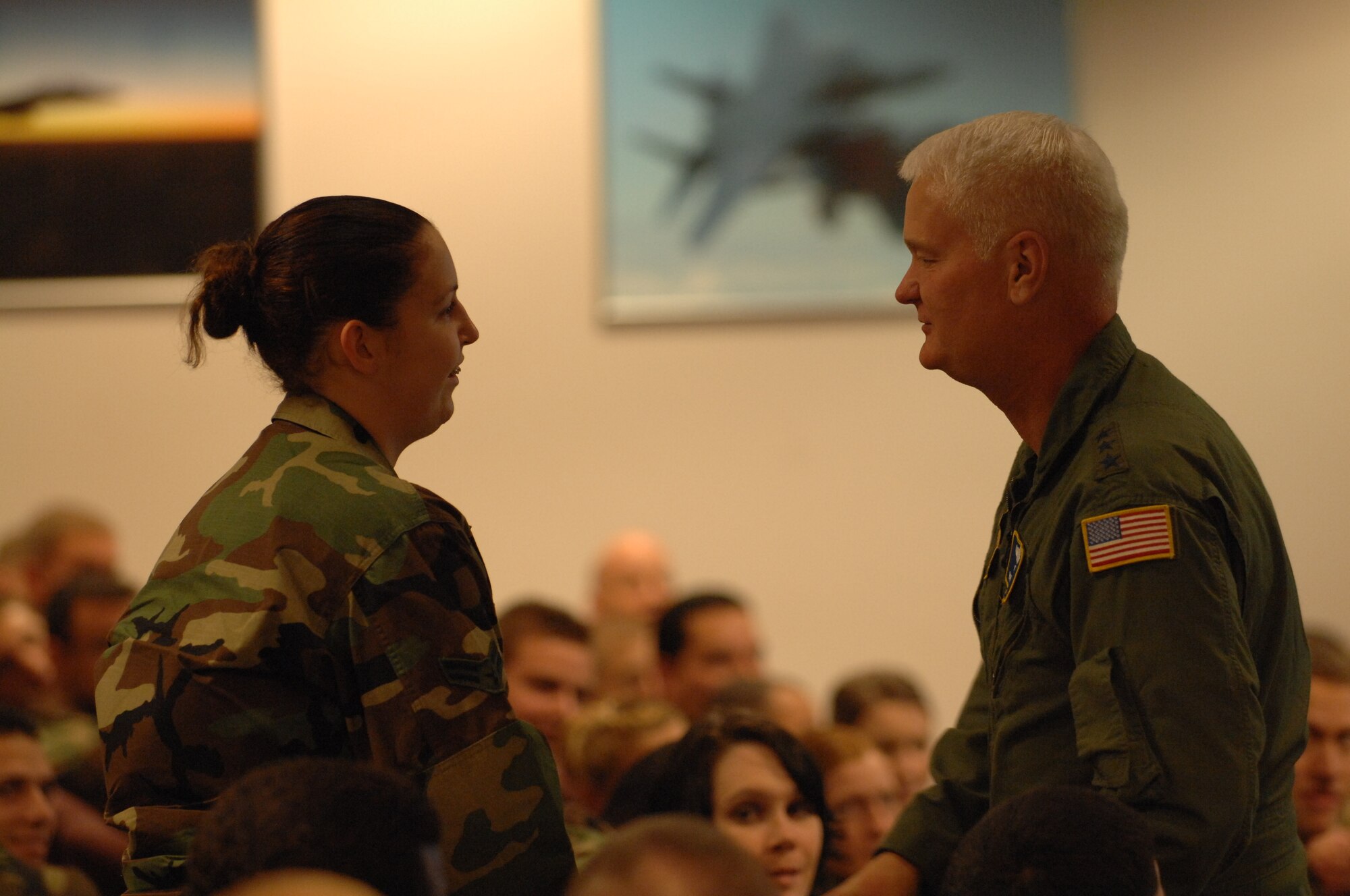Lt. Gen. Robert Bishop, 3rd Air Force commander, coins Airman 1st Class Sara Warner, 48th Comptroller Squadron, for correctly answering a question during the Oct. 16 safety briefing. General Bishop and Chief Master Sgt. Marin Klukas, 3rd Air Force command chief master sergeant are visiting bases to brief Airmen on seasonal safety. (U.S. Air Force photo by Airman 1st Class John Easterling)