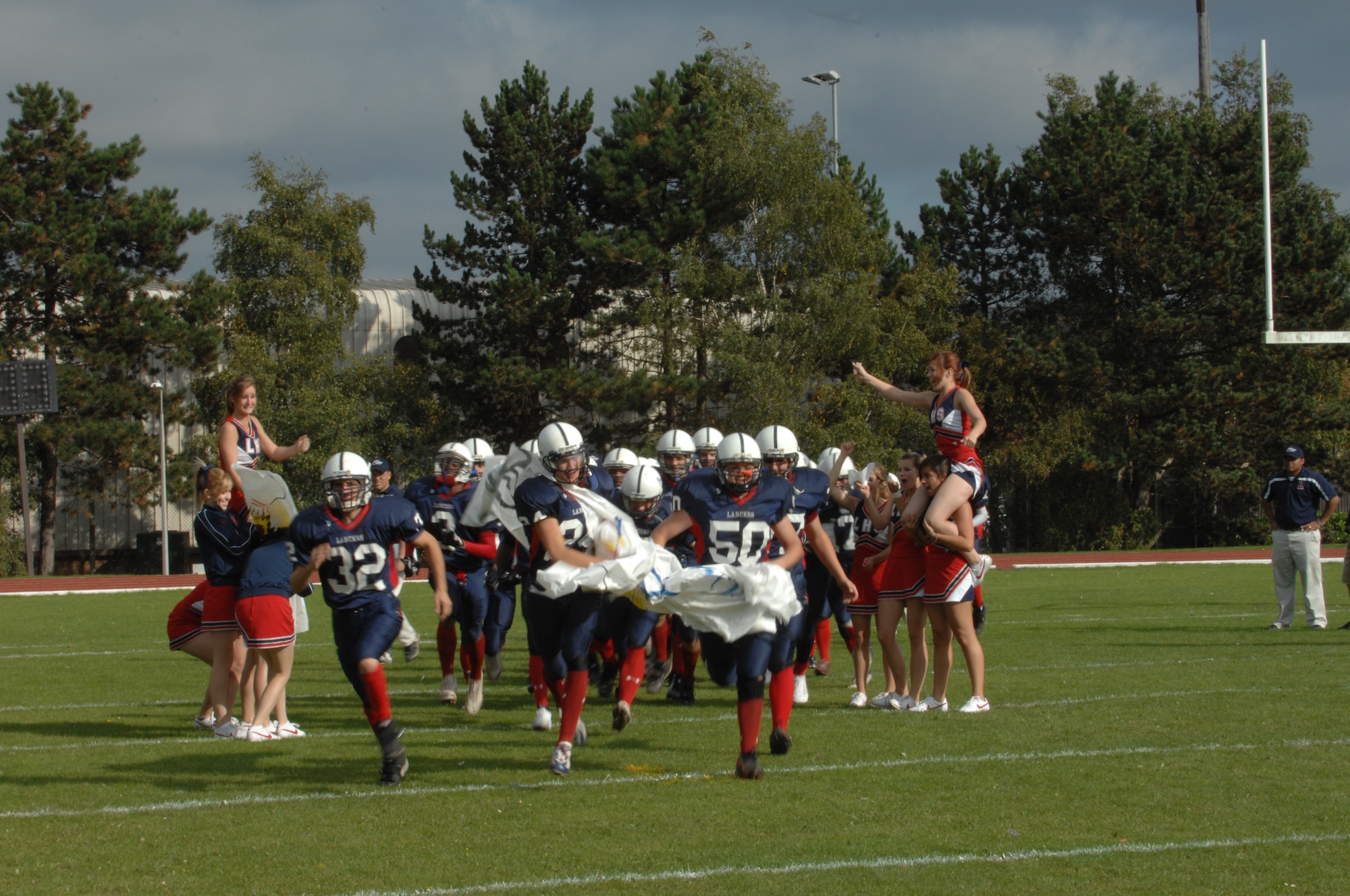 The Lakenheath High School Lancers burst out the gate before the Oct 13 homecoming game. The Lancers played against the Heidelberg High School Lions from Germany. The game ended with the Lions defeating the home team 27 -14. (U.S. Air Force photo by Airman 1st Class John Easterling)