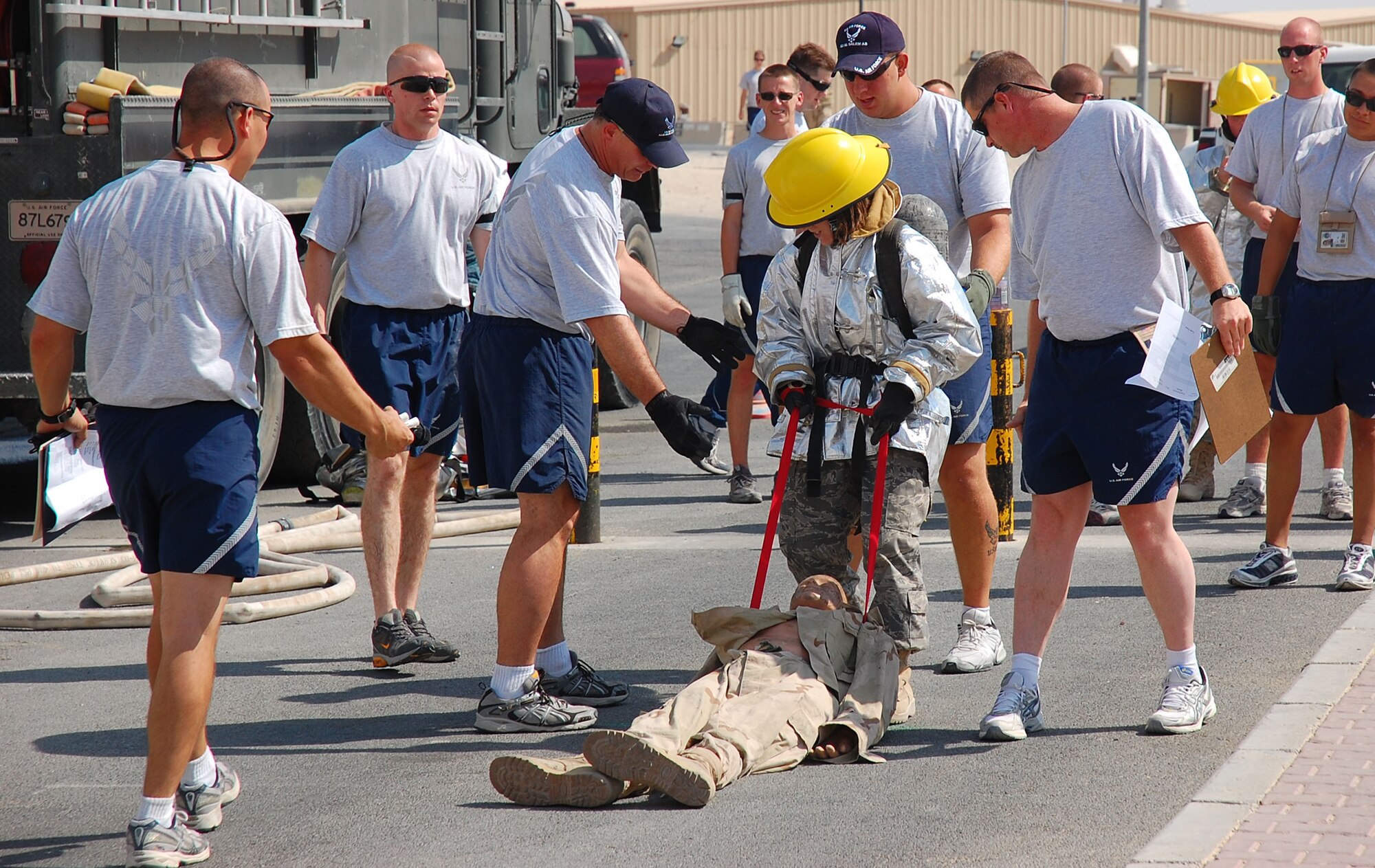 SOUTHWEST ASIA -- Staff Sgt. Kristen Coyne, 386th Expeditionary Civil Engineering Squadron emergency management, is encouraged by fellow Airmen to keep moving as she pulls a 135-pound dummy 100 feet while participating in a firefighter challenge here Oct. 14.  Sergeant Coyle is deployed from 125th Air Refueling Wing, Great Falls, Mont. (U.S. Air Force photo by Staff Sgt. Tia Schroeder)