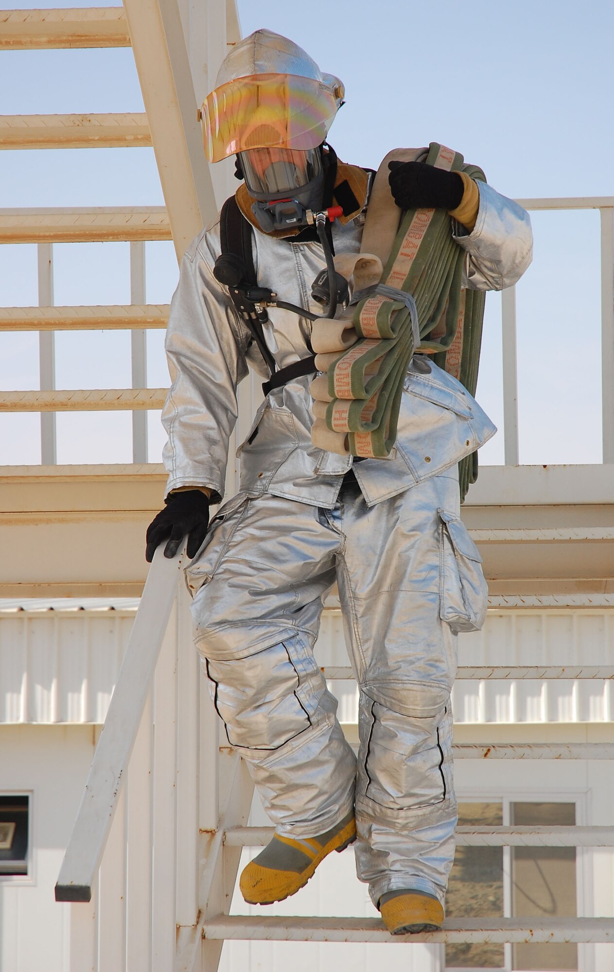 SOUTHWEST ASIA -- Senior Airman Nicholas Murdock, 386th Expeditionary Civil Engineering Squadron firefighter, descends a 40-foot tower while demonstrating a simulated fire rescue during the firefighter challenge here Oct. 14.  Airman Murdock is deployed from 121st Air Refueling Wing, Columbus, Ohio.  (U.S. Air Force photo by Staff Sgt. Tia Schroeder)