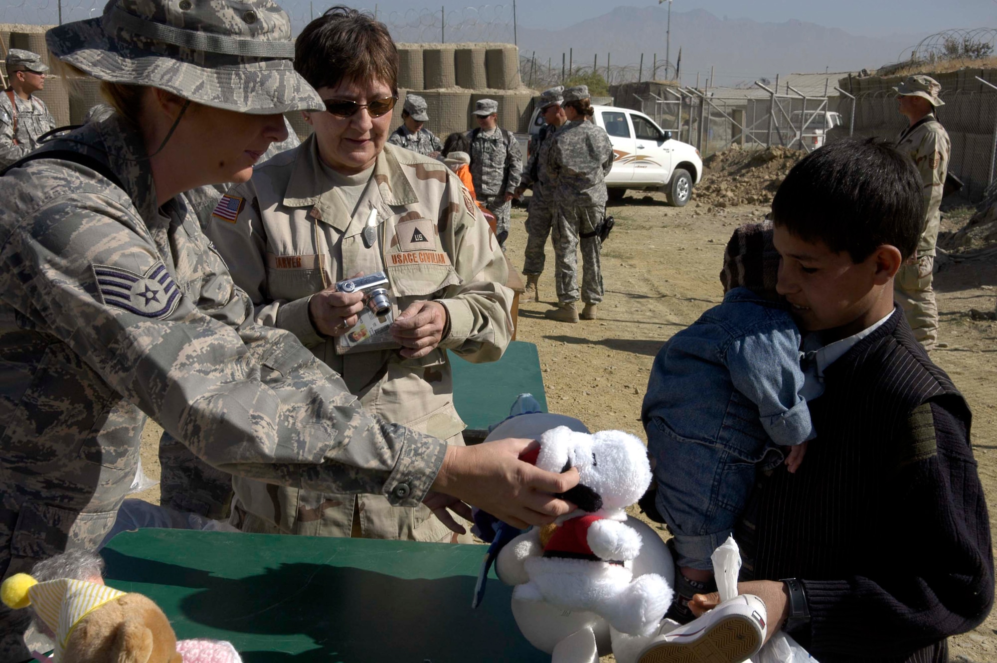 BAGRAM AIRFIELD, Afghanistan -- Air Force Staff Sgt. Tracy Anderson passes out toys to Afghan children during an Operation Care visit to the Korean Hospital here Oct. 17.  Operation Care is an all-volunteer effort that provides clothes, school and hygiene supplies, toys and candy to Afghan villagers.  (U.S. Air Force Photo by Capt. Michael Meridith)
