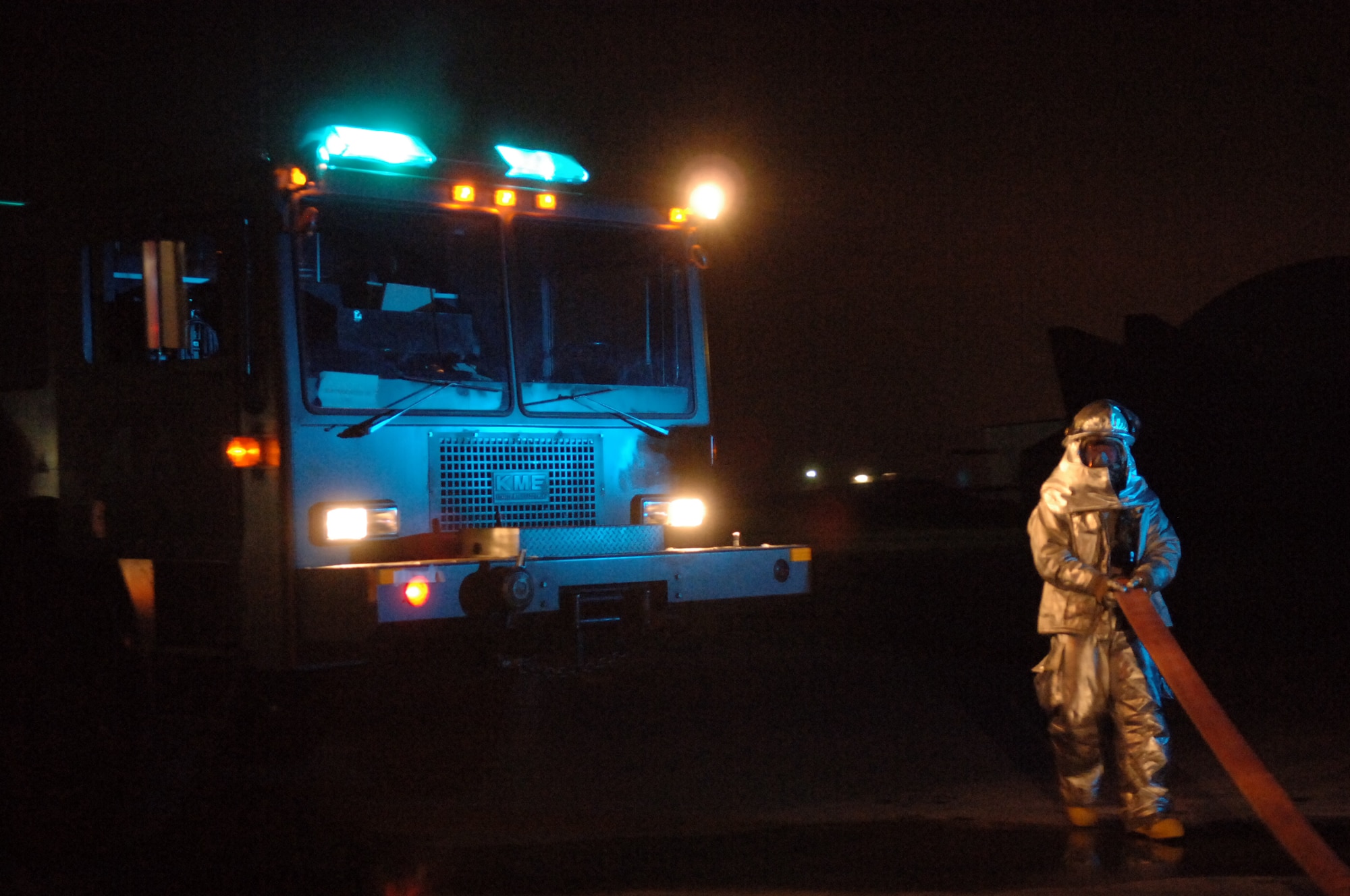 A 435th Civil Engineer Squadron firefighter gathers a fire hose after responding to an aircraft engine fire during the Operational Readiness Exercise at the field training site on Ramstein Air Base, Germany, Oct. 17. The exercise is designed to test the ability of Airmen to survive in austere environments with chemical, biological, radiological, nuclear and explosive hazards.  (U.S. Air Force Photo by Airman 1st Class Kelly LeGuillon) 