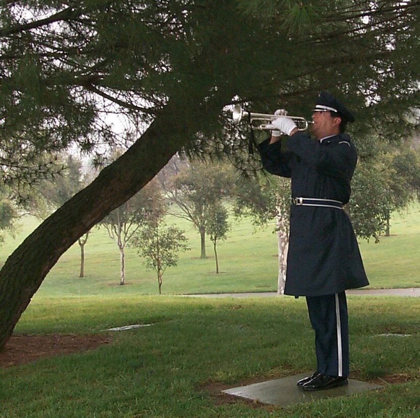 Tech. Sgt. Robert Carreon of the Blue Eagles Honor Guard plays Taps during a funeral ceremony at California's Riverside National Cemetery. (U.S. Air Force photo/Gwen McKenzie)