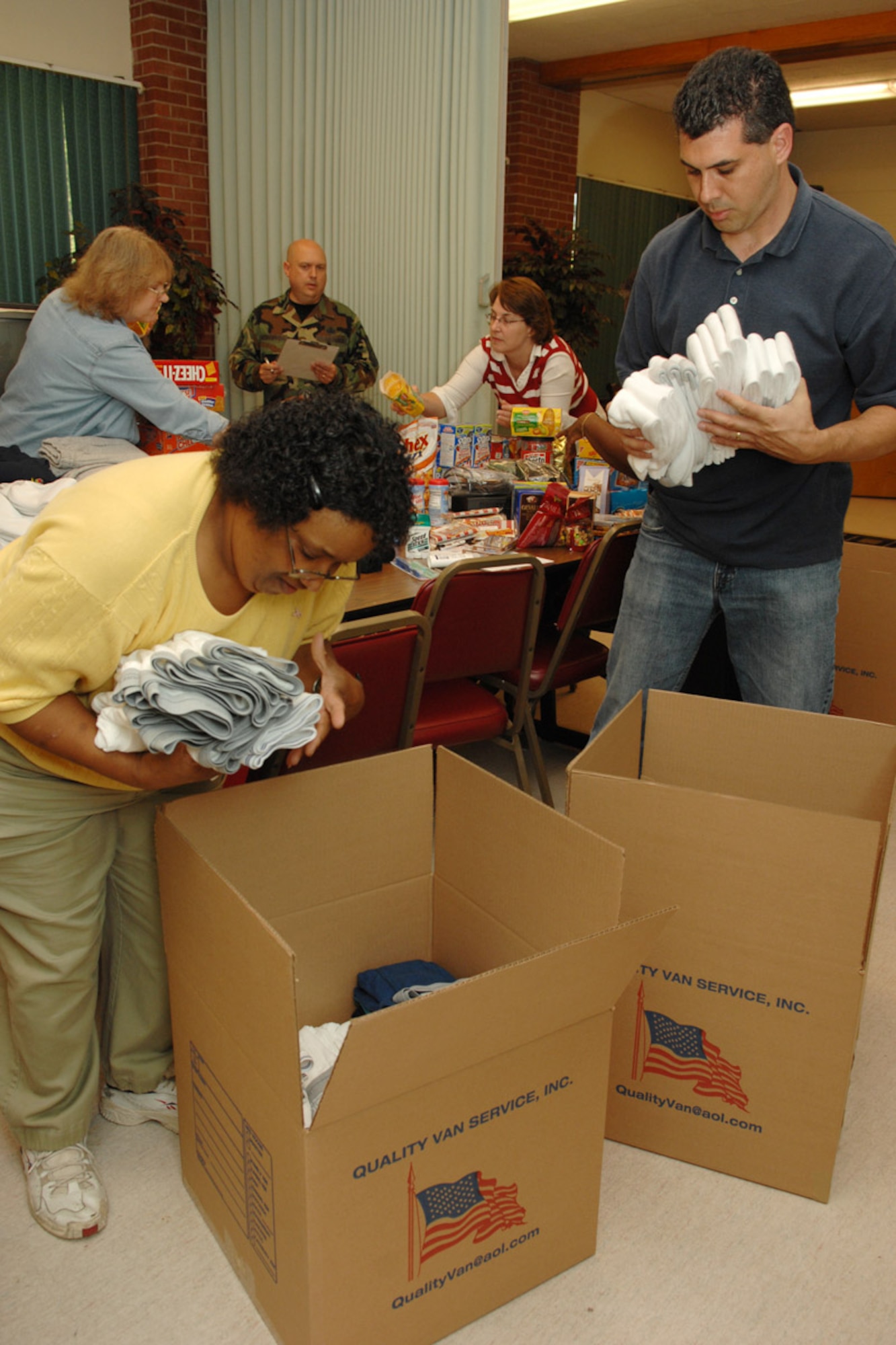 Retired Master Sgt. Battista Turlington, volunteer, and Rich Roberts, Young Adult Ministry Coordinator, pack up donations at the Bethel Manor Chapel Oct. 17. The items, which were donated by dorm residents, Langley Catholic and Protestant parishes and local Airmen, will be shipped to deployed Air Force chaplains in Balad and Afghanistan. From there, items such as snacks, DVDs, game systems and clothing will be distributed to deployed servicemembers. (U.S. Air Force photo/Staff Sgt. Katrina Shellman)