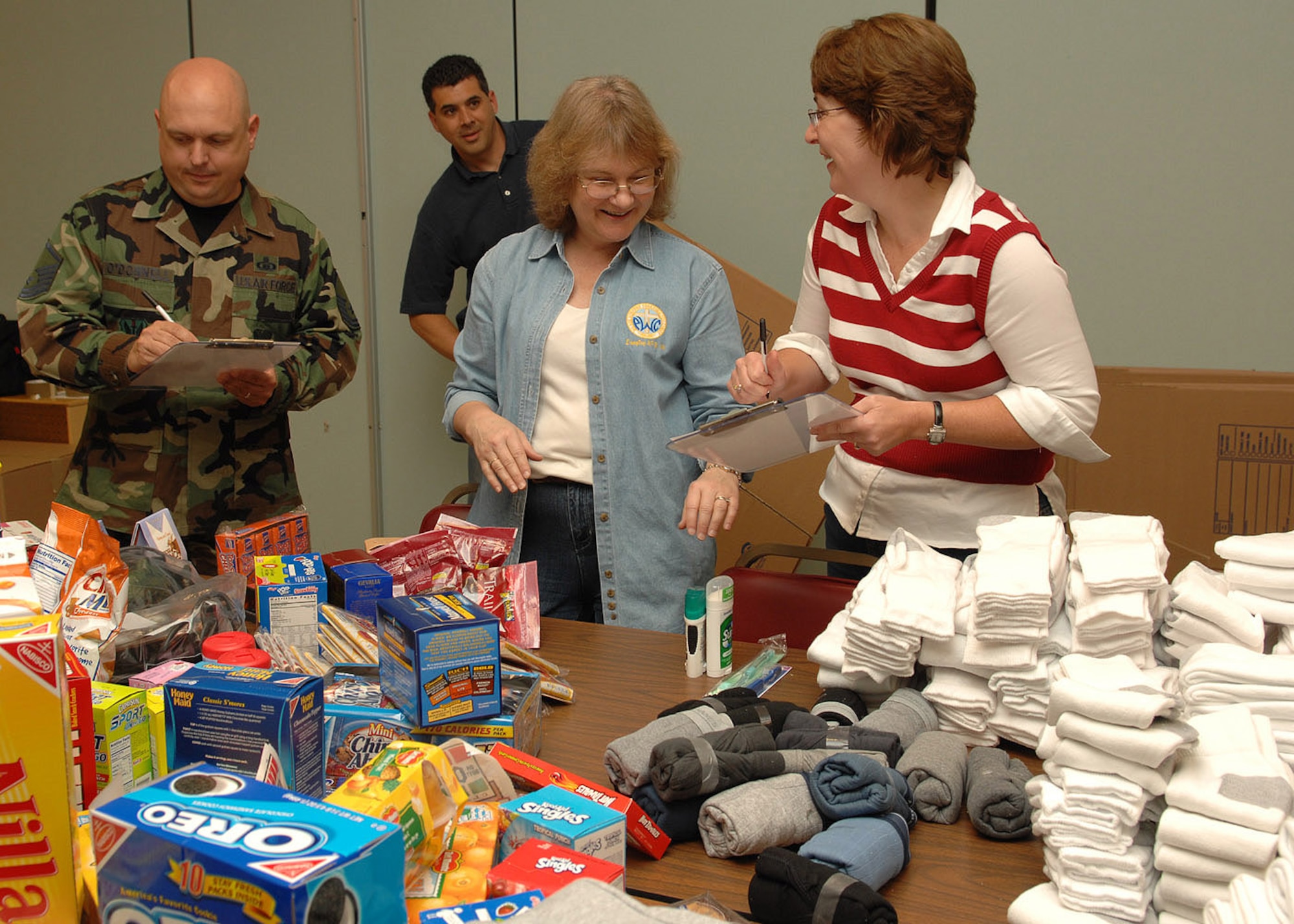 Master Sgt. Michael O’Donnell, 1st Fighter Wing Chapel superintendent, Lynn Torrenti , Protestant parrish coordinator and Joanna McCormack, Catholic coordinator, take inventory of donations at the Bethel Manor Chapel Oct. 17. The items, which were donated by dorm residents, the Catholic and Protestant parishes and local Airmen, will be used will be shipped to deployed Air Force chaplains in Balad and Afghanistan. From there, items such as snacks, DVDs, game systems and clothing will be distributed to deployed servicemembers. (U.S. Air Force photo/Staff Sgt. Katrina Shellman)