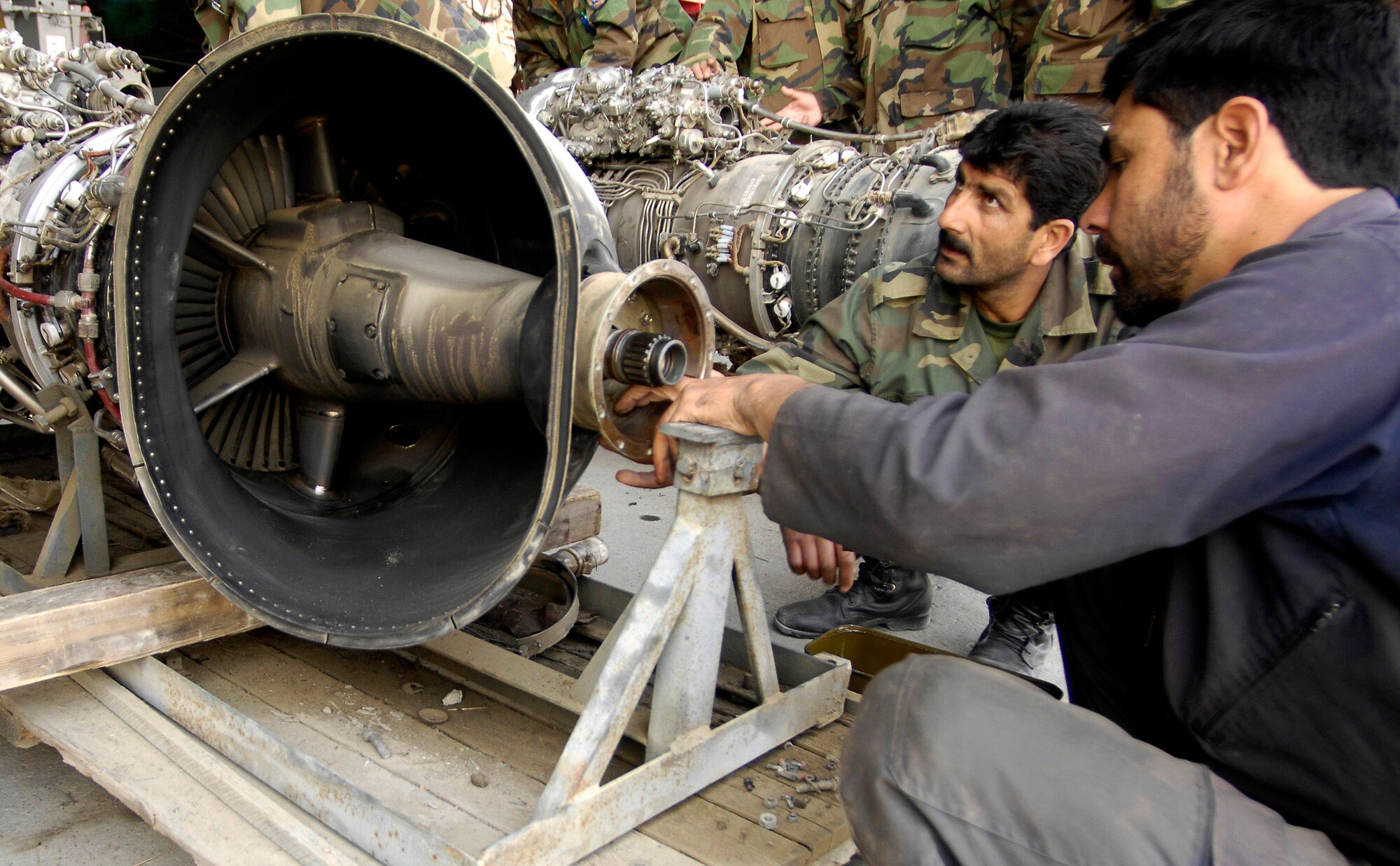 Afghan national army air corps aircraft mechanics work on an engine Oct 18 at Kabul International Airport, Afghanistan. U.S. Air Force Airmen advise and mentor the ANA air corps, helping to rebuild and train its force. (U.S. Air Force photo/Staff Sgt. Brian Ferguson)
