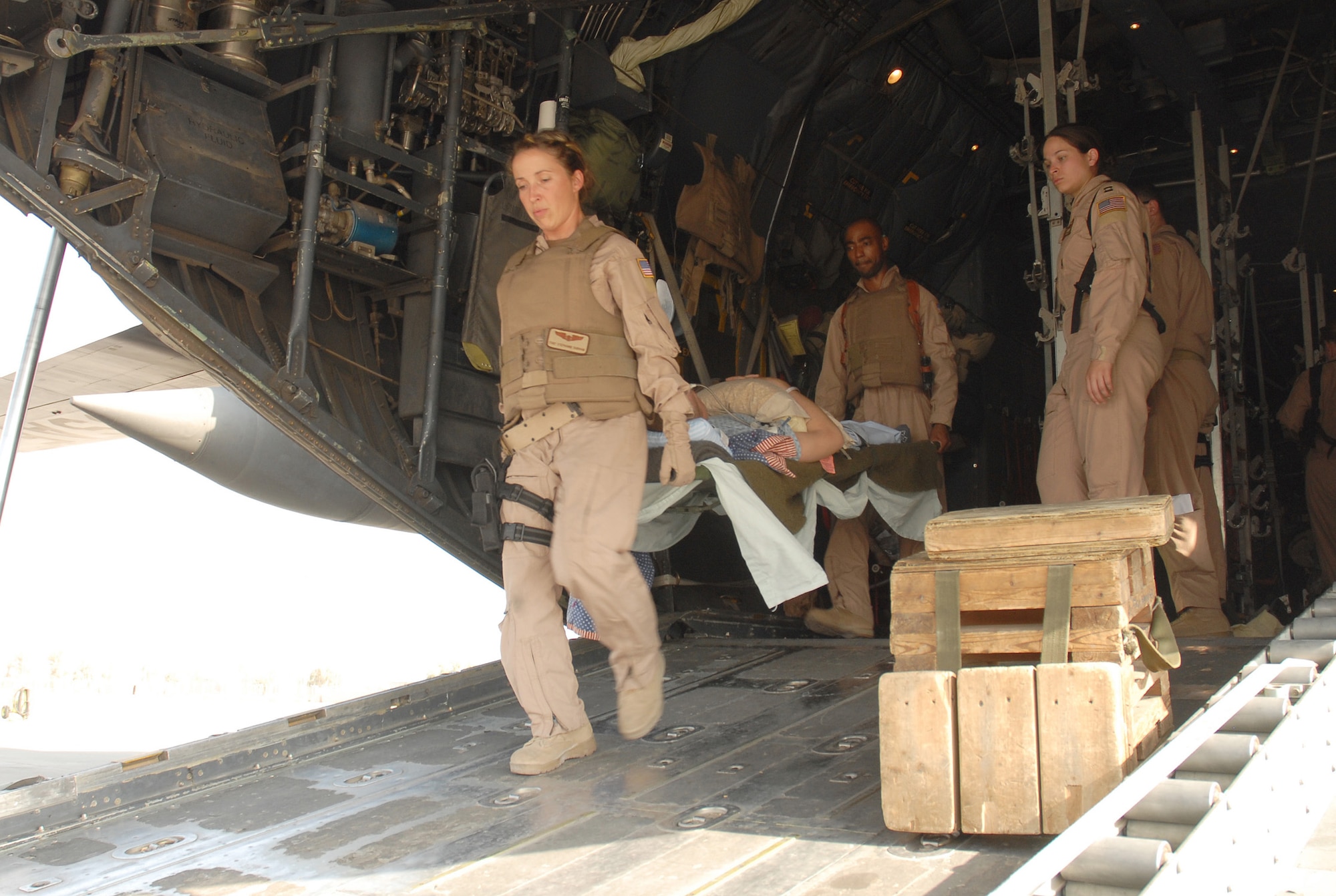 Tech. Sgts. Stephanie Durham and Ricardo Brown with the 379th Expeditionary Aeromedical Evacuation Squadron carefully move a littered patient on to an awaiting ambulance Oct. 14. The 379th EAES treat patients throughout Southwest Asia. The ability to rapidly respond to various medical needs in the AOR gives the U.S. and coalition forces greater flexibility to preserve life in the Global War on Terror. Durham and Brown are deployed from Scott AFB, Ill.