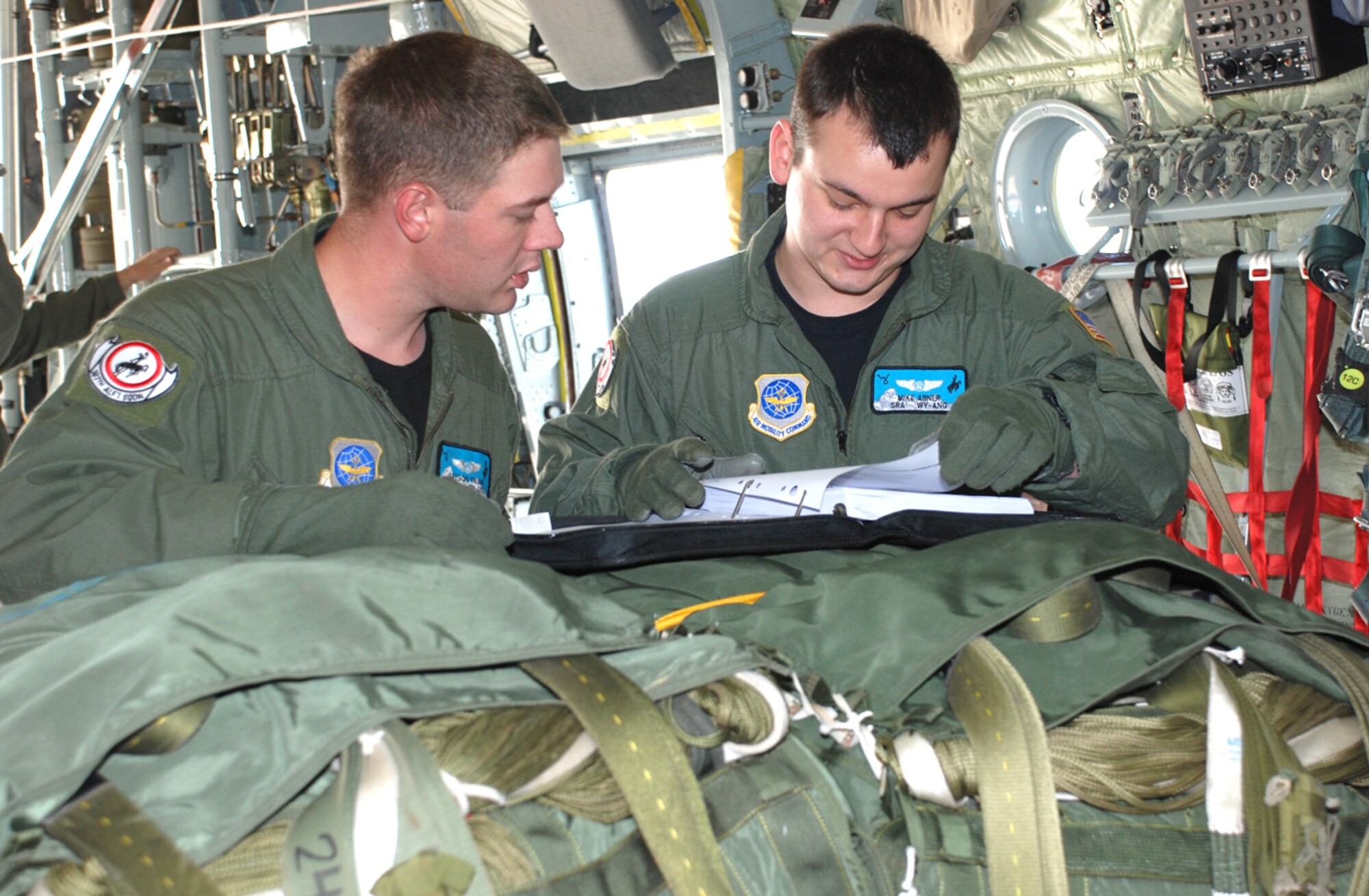Senior Airman Mike Abner and Senior Airman Bryson Swank, 187th Airlift Squadron, run through pre-flight checklists during cargo pallet drop training Oct. 7.