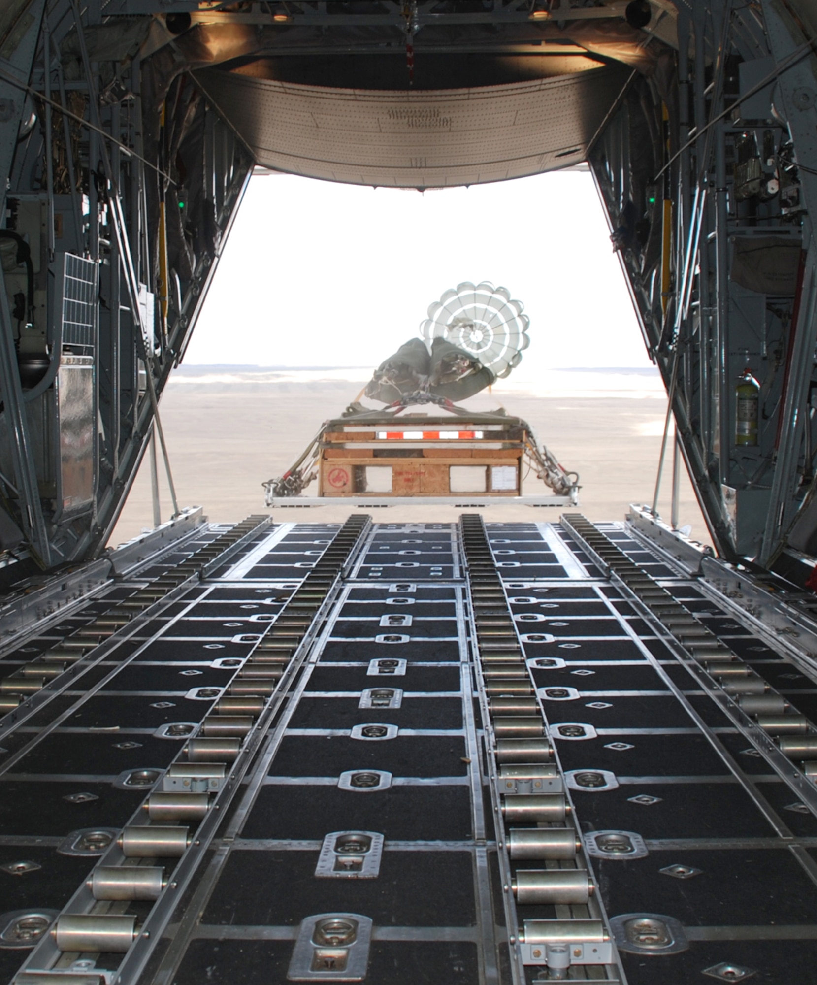A cargo pallet drops from a C-130 aircraft during a training flight Oct. 7. The pallet is released from the aircraft when a connected parachute is deployed and catches winds out the back.