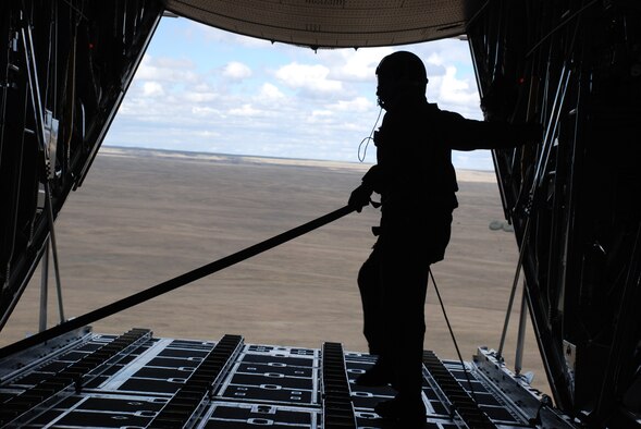 Senior Airman Mike Abner, 187th Airlift Squadron, watches a cargo load parachute to the ground during a training flight Oct. 7. Airman Abner is a loadmaster with the Wyoming Air National Guard (Photo by Airman Alex Martinez).