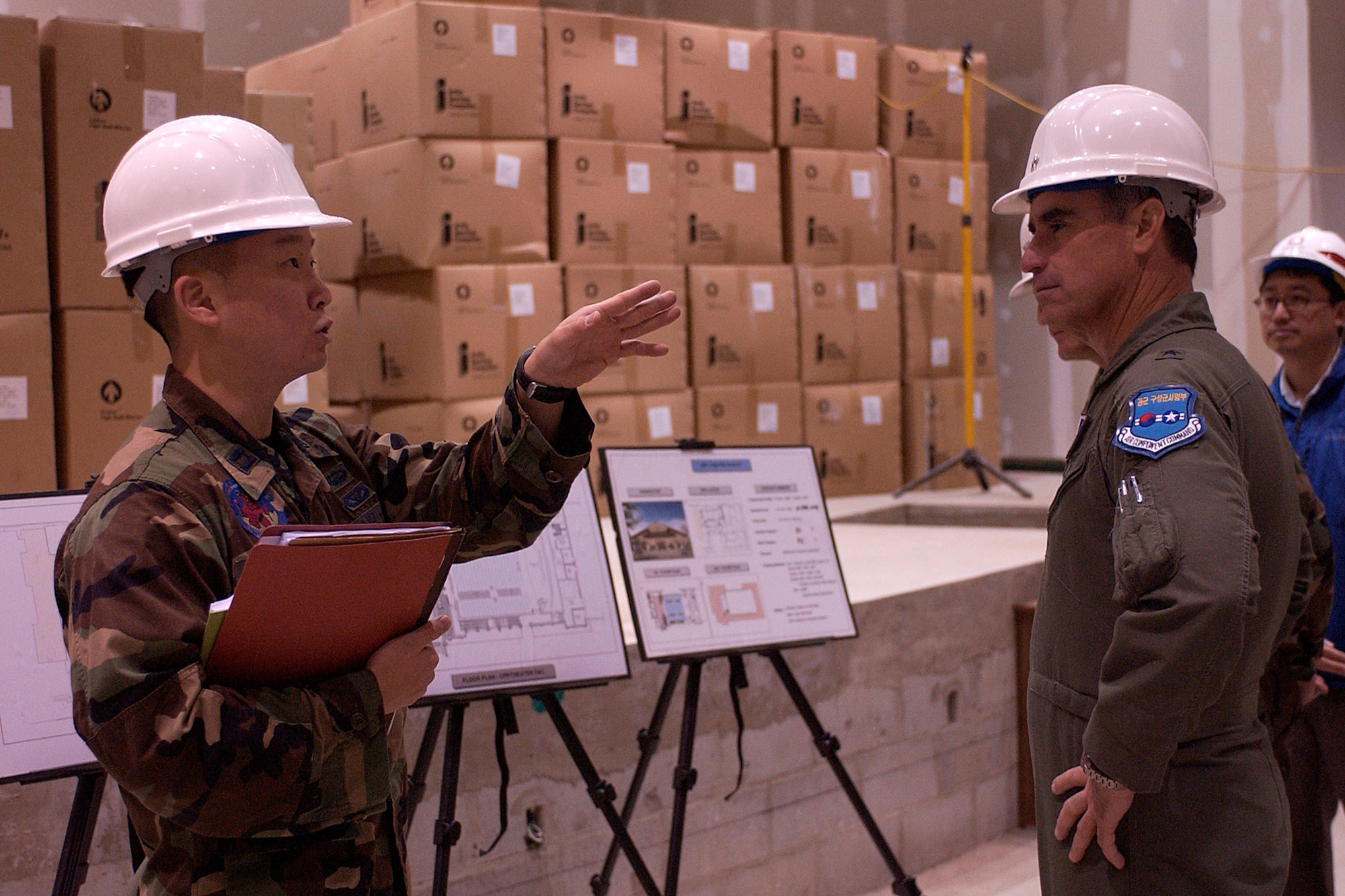 KUNSAN AIR BASE, South Korea -- Captain Peter Choi, 8th Civil Engineer Squadron, explains to Brig. Gen. Harold Moulton, 7th Air Force vice commander, the design plans of the new base theater currently under construction Oct. 18 here.  Besides touring the new theater Gen. Moulton flew with the 80th Fighter Squadron, visited the water treatment plant and spent the majority of his time speaking with Airmen from across the base providing them with general officer mentoring and thanking them for their service. (U.S. Air Force photo/Senior Airman Giang Nguyen)