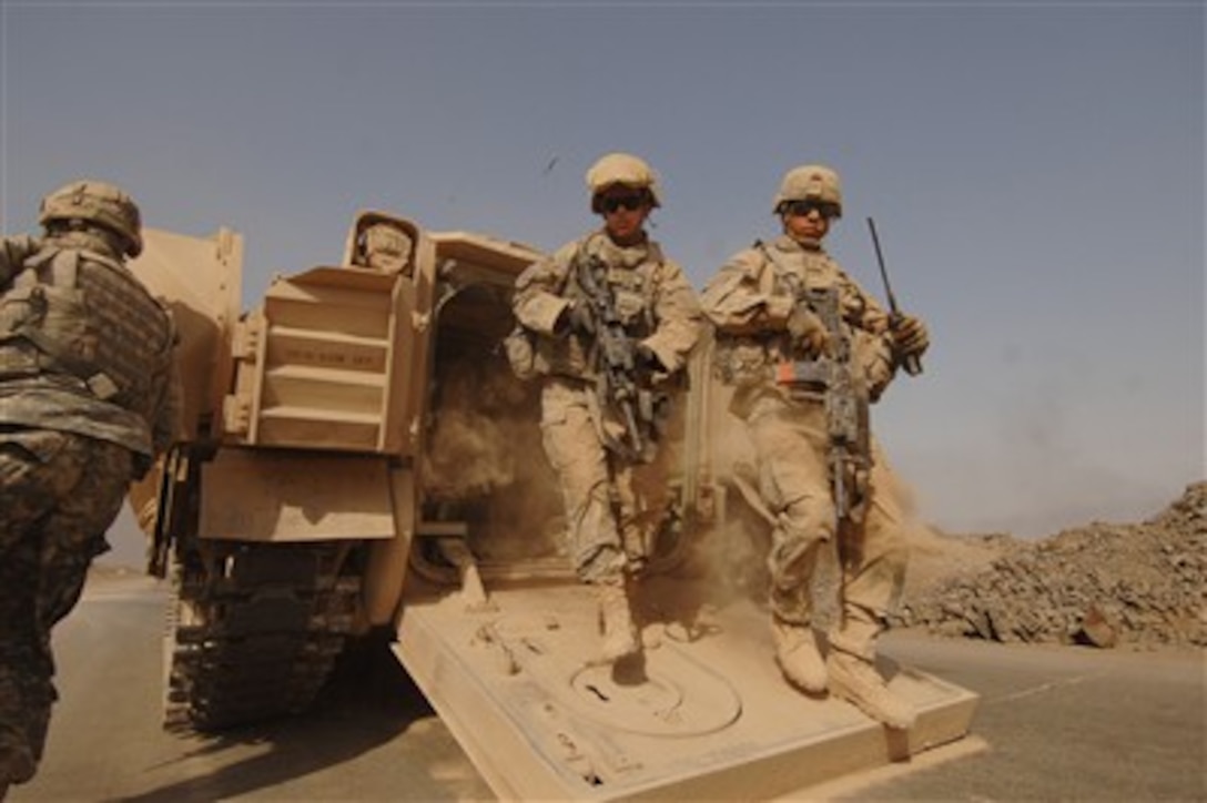 Two U.S. Army soldiers from Alpha Company, 1st Battalion, 10th Artillery Regiment, 3rd Brigade Combat Team, 3rd Infantry Division dismount from the back of a Bradley Fighting Vehicle to conduct a cordon and search at a brick factory in Narhwan, Iraq, on Oct. 12, 2007. 