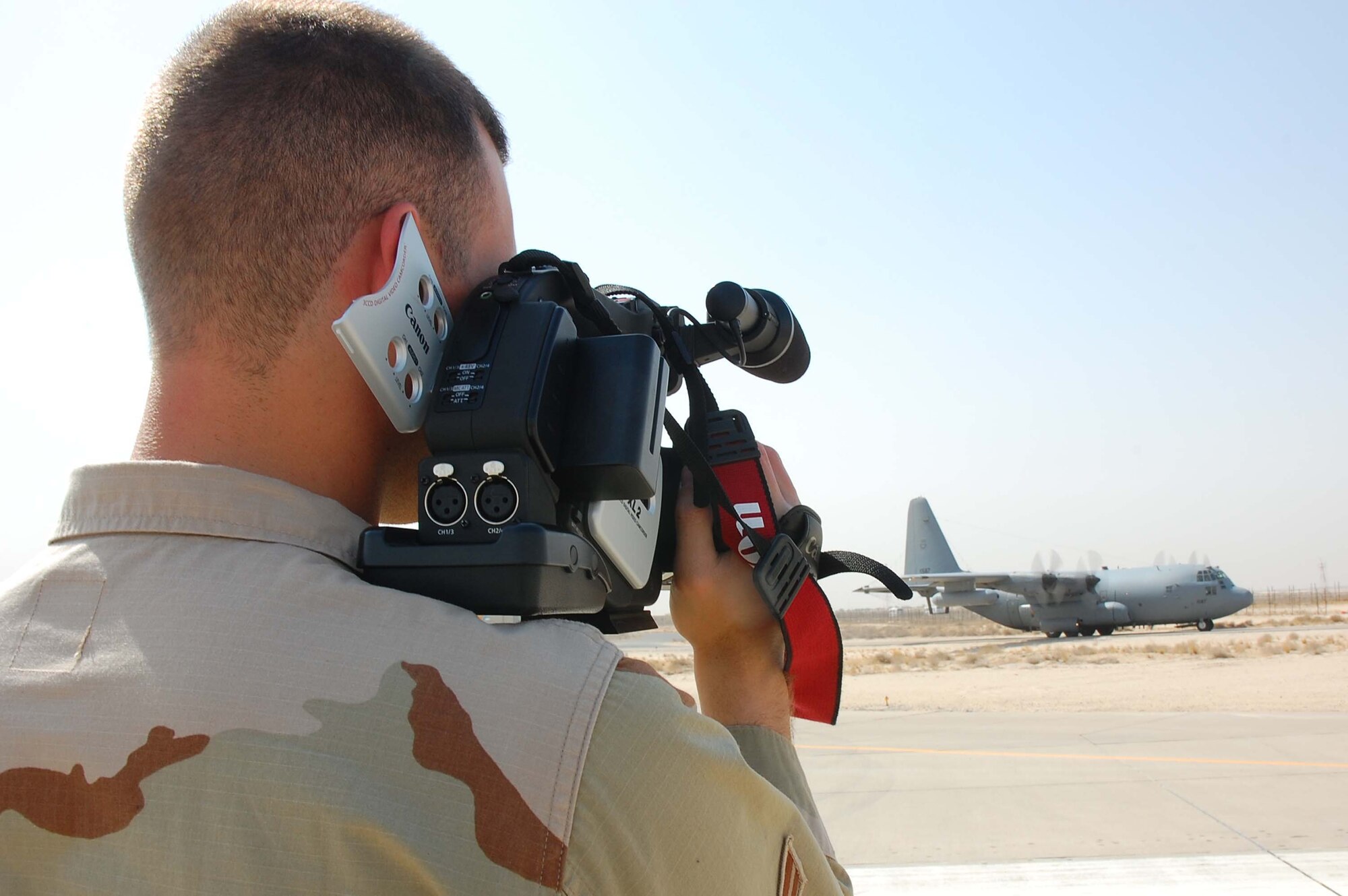 SOUTHWEST ASIA -- Airman 1st Class Ryan Yeckering, 386th Air Expeditionary Wing broadcaster, captures a C-130E Hercules aircraft taxi down the flightline here Oct. 19.  Airman Yeckering is deployed from Goodfellow AFB, Texas.  (U.S. Air Force photo by Staff Sgt. Tia Schroeder)