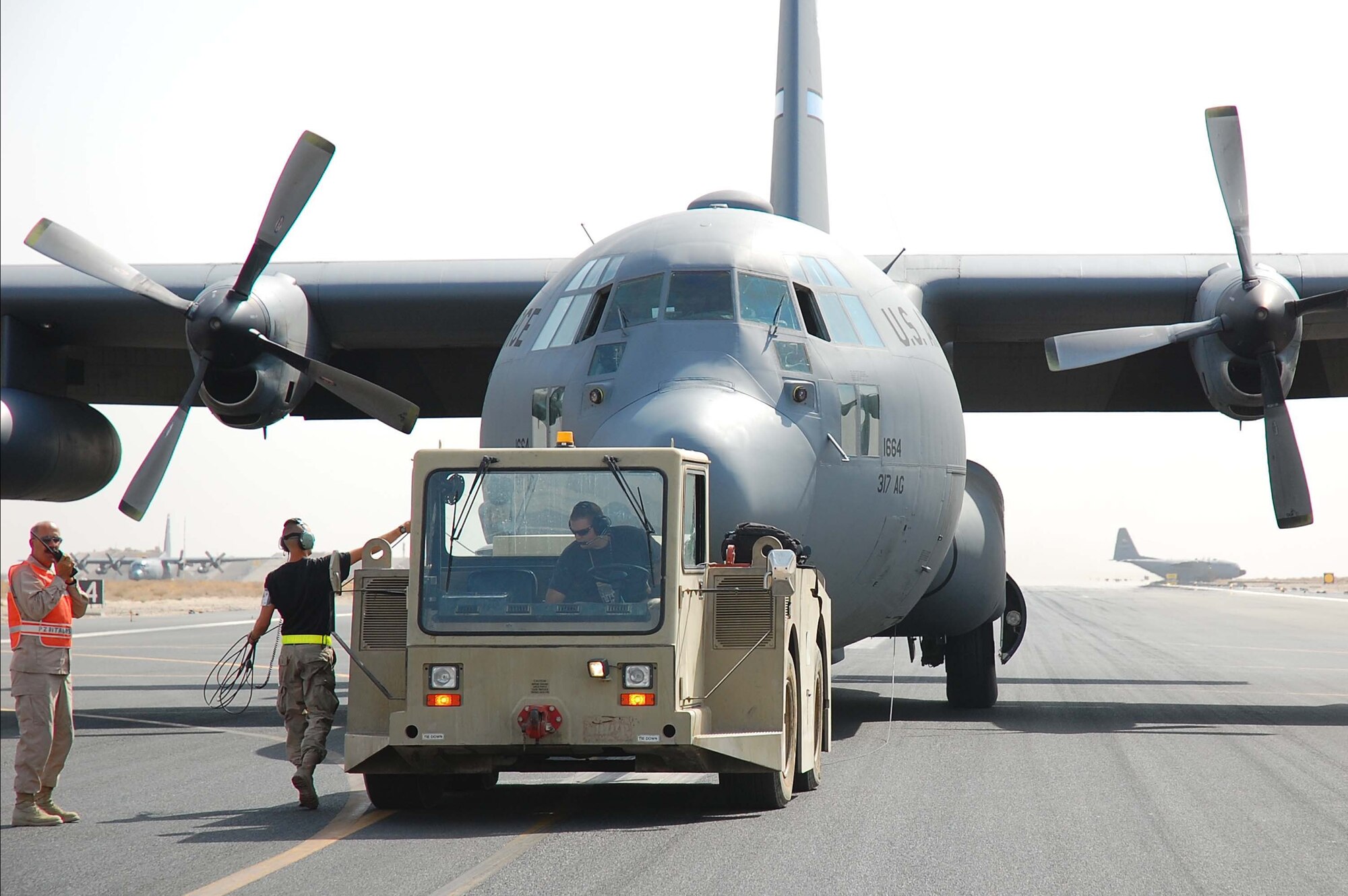 SOUTHWEST ASIA -- An airfield emergency response team quickly responds to an in-flight emergency involving a C-130E Hercules aircraft here Oct. 19.  The C-130J is the latest addition to the C-130 fleet and will replace aging C-130Es. The C-130J incorporates state-of-the-art technology to reduce manpower requirements, lower operating and support costs, and provides life-cycle cost savings over earlier C-130 models. Compared to older C-130s, the J model climbs faster and higher, flies farther at a higher cruise speed, and takes off and lands in a shorter distance.  (U.S. Air Force photo by Staff Sgt. Tia Schroeder)