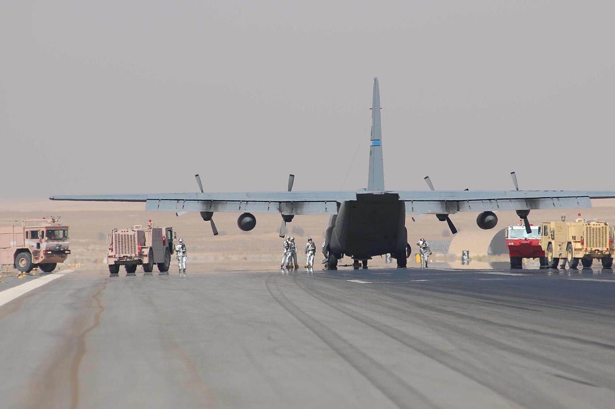 SOUTHWEST ASIA -- An airfield emergency response team quickly responds to an in-flight emergency involving a C-130E Hercules aircraft here Oct. 19.  The C-130J is the latest addition to the C-130 fleet and will replace aging C-130Es. The C-130J incorporates state-of-the-art technology to reduce manpower requirements, lower operating and support costs, and provides life-cycle cost savings over earlier C-130 models. Compared to older C-130s, the J model climbs faster and higher, flies farther at a higher cruise speed, and takes off and lands in a shorter distance.  (U.S. Air Force photo by Staff Sgt. Tia Schroeder)