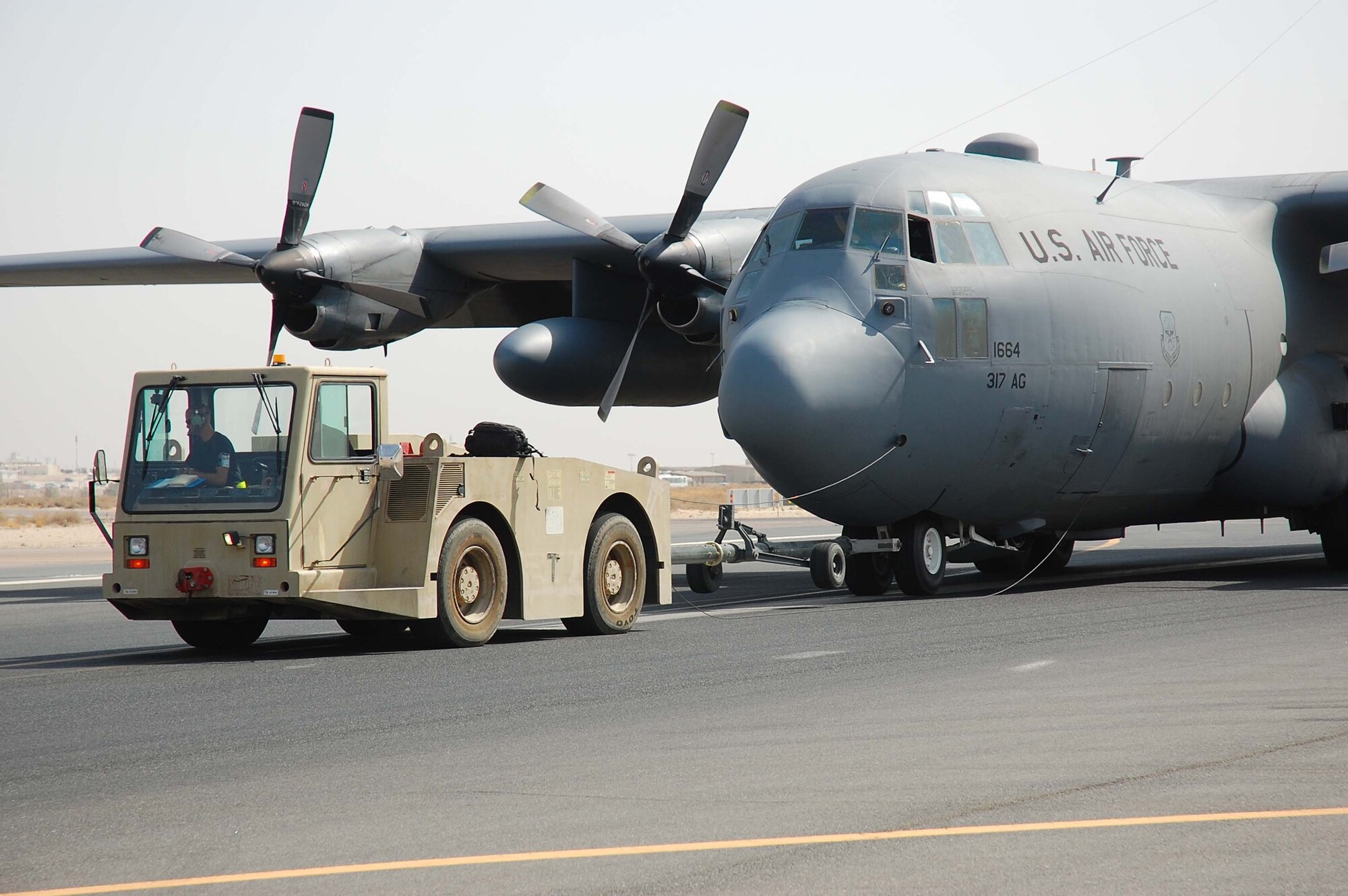 SOUTHWEST ASIA -- An airfield emergency response team quickly responds to an in-flight emergency involving a C-130E Hercules aircraft here Oct. 19.  The C-130J is the latest addition to the C-130 fleet and will replace aging C-130Es. The C-130J incorporates state-of-the-art technology to reduce manpower requirements, lower operating and support costs, and provides life-cycle cost savings over earlier C-130 models. Compared to older C-130s, the J model climbs faster and higher, flies farther at a higher cruise speed and takes off and lands in a shorter distance.  (U.S. Air Force photo by Staff Sgt. Tia Schroeder)