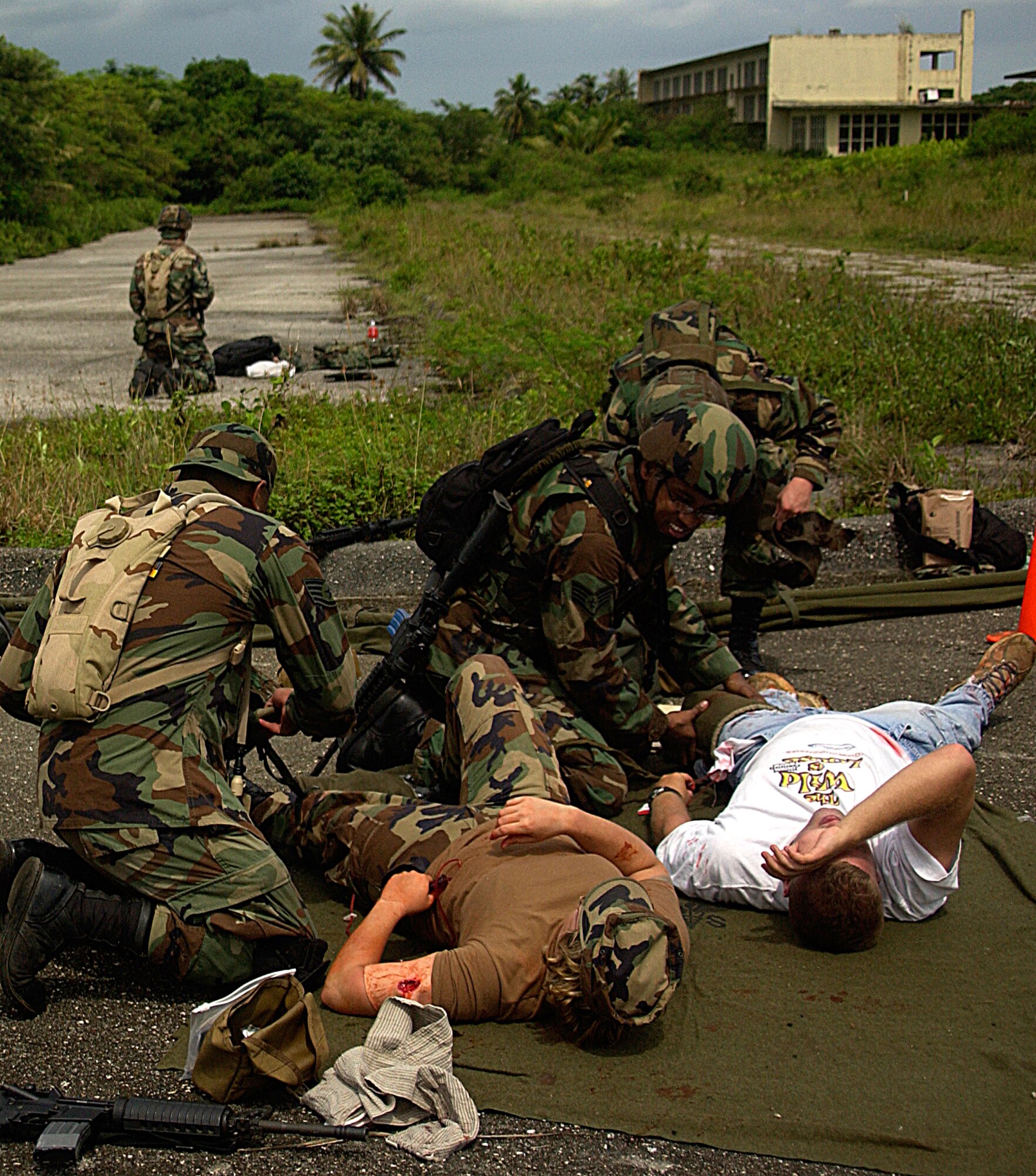 36th Contingengy Response Group members, Staff Sergeants Tavis Salas and Juan Pridgen, simulate treating casualties using Self-Aid and Buddy Care until help arrives during their field training exercise held Oct. 18. (U.S. Air Force Photo/Airman 1st Class Carissa Morgan)