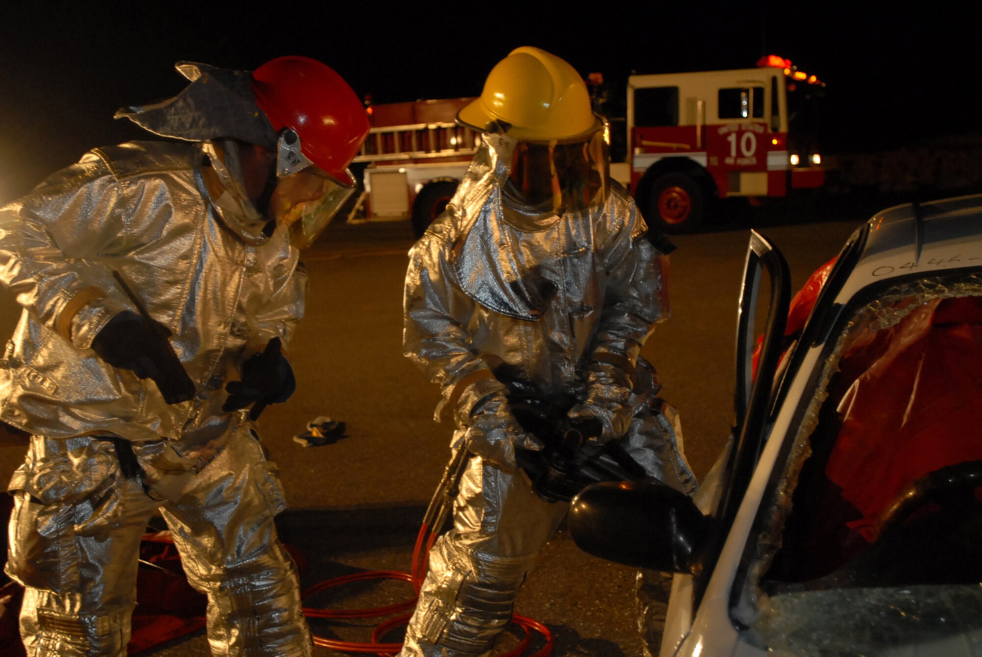Firefighters use the jaws-of-life to gain entry into a car and free a trapped “victim” during Local Operational Readiness Exercise Beverly High 08-1 Oct. 23.  The scenario tested the speed of firefighters in responding, freeing the victim and administering self-aid and buddy care.  The firefighters are assigned to the 18th Civil Engineer Squadron. (U.S. Air Force photo/Senior Airman Darnell T. Cannady)