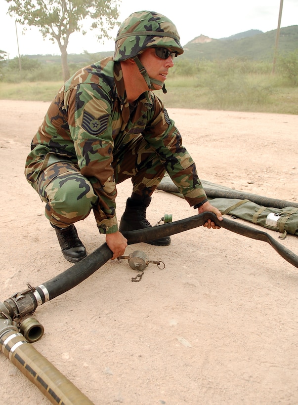 SOTO CANO AIR BASE, Honduras – Air Force Tech. Sgt. Branden Bedure sets up hoses for a Refuel on the Move, or ROM, during a convoy exercise near the village of Lejamani Oct. 19.  The purpose of the training was to keep the vehicles in operation and identify any issues with them so they could be fixed.  (U.S. Air Force photo by Staff Sgt. Austin M. May)