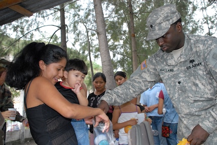 CUESTA DE LA VIRGEN, Honduras -- Army Spec. Roderick Ballard, a medical logistics technician, hands out candy to local Honduran children Oct. 19 during a Medical Readiness Training Exercise.  This MEDRETE educated 785 Hondurans on preventive medicine issues such as hand washing, food preparation and personal hygiene.  Of those 785, doctors examined 352 patients and the dentist treated 139 patients. (U.S. Air Force photo/Tech. Sgt. Sonny Cohrs)
