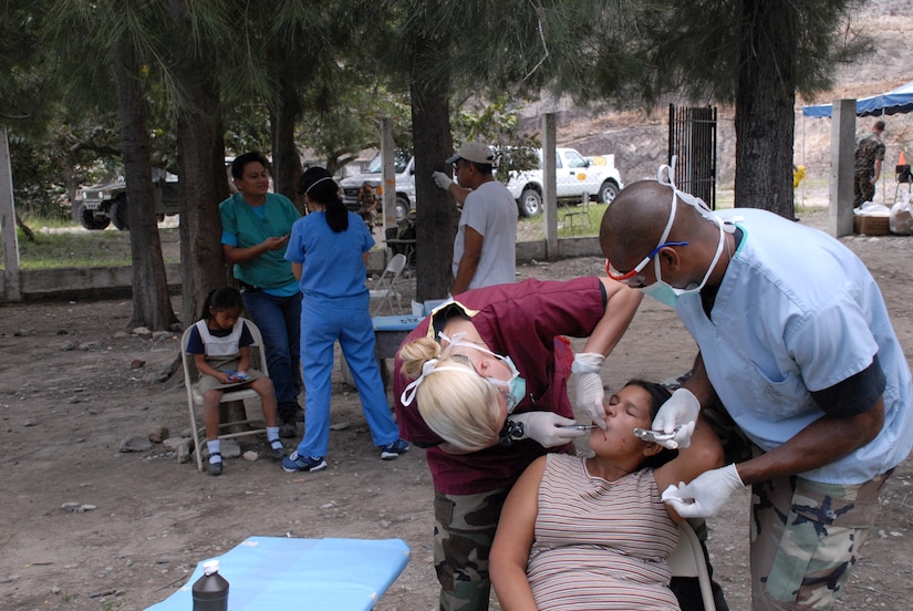 CUESTA DE LA VIRGEN, Honduras -- Air Force Capt. (Dr.) Beth Jablonowski, left, and Air Force Tech. Sgt. Billy McCoy, both assigned to the Medical Element at Soto Cano Air Base, Honduras, extract the tooth of a local Honduran during a Medical Readiness Training Exercise Oct. 19.  The team treated a total of 139 dental patients during the two-day MEDRETE. (U.S. Air Force photo/1st Lt. Erika Yepsen)