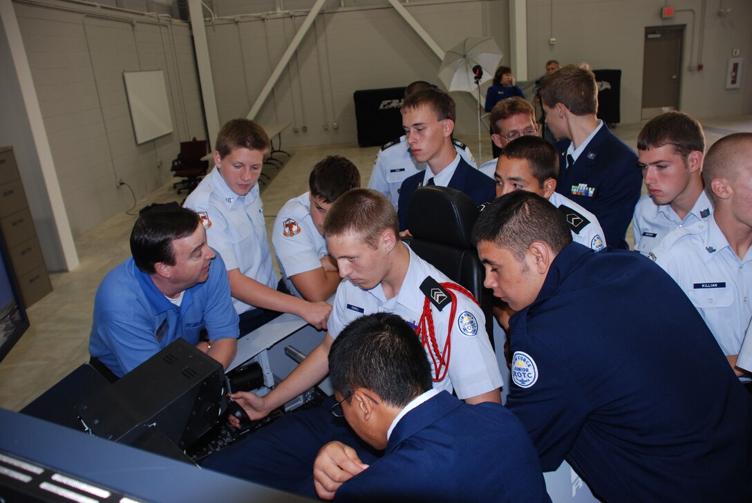 Cadet Lt. Col. Neil Kendall (center), a member of the Burkburnett Junior ROTC detachment, tries his hand at flying the F-22A Raptor flight simulator Oct. 18 during the group's visit to the new F-22 Raptor Maintenance Training Facility. The facility officially opened Oct. 19. (U.S. Air Force photo/George Woodward)