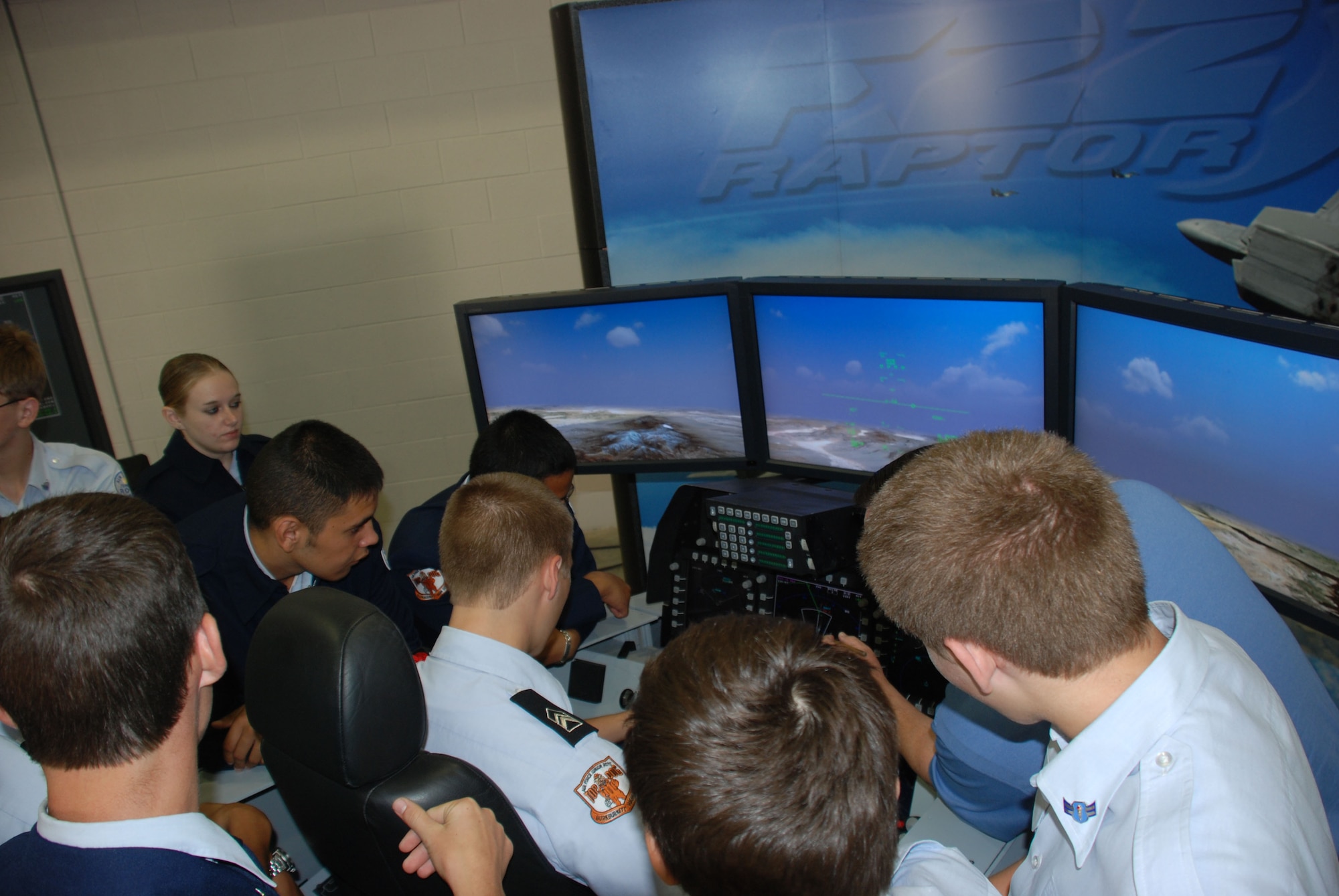 Cadets from the Burkburnett Junior ROTC huddle around an F-22A Raptor flight simulator Oct. 18, one day before the opening of the F-22 Raptor Maintenance Facility at Sheppard. The cadets toured the facility and took turns "flying" missions in the simulator owned by Boeing. (U.S. Air Force photo/George Woodward)
