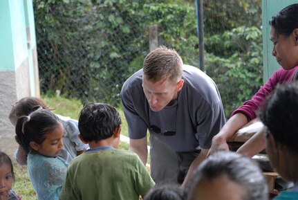 ALDEA BELLA VISTA, Honduras -- U.S. Air Force Maj. Jason Clark hands food to children in Bella Vista Oct. 20.  Major Clark was one of approximately 50 U.S. military members who hiked up Comayagua Mountain to bring 450 pounds of food to the residents in remote Bella Vista.  The hike was organized by the JTF-Bravo chaplain to support local Hondurans.  Approximately 50 military members participated in the hike which was the second in a series of five planned to date. (U.S. Air Force photo/1st Lt. Erika Yepsen)