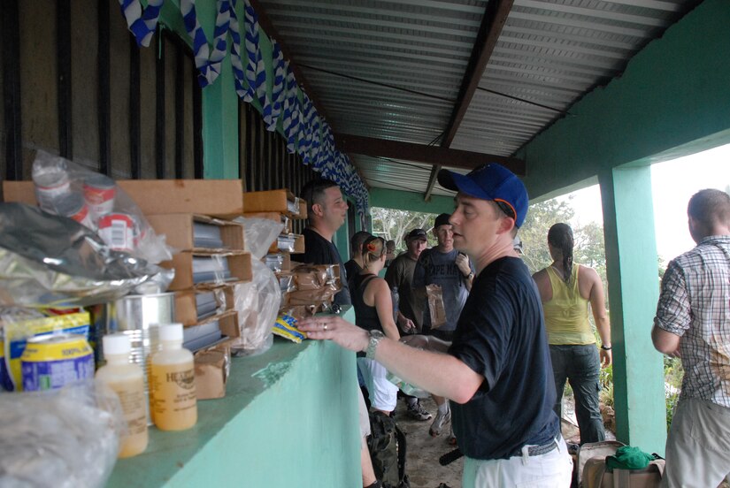 ALDEA BELLA VISTA, Honduras -- U.S. Air Force Capt. Mike Epper stacks the food he carried up Comayagua Mountain outside of the Bella Vista school Oct. 20.  Captain Epper was one of approximately 50 military members from Joint Task Force Bravo at Soto Cano Air Base that participated in the hike, helping to carry nearly 450 pounds of food to citizens in Bella Vista.  The hike was organized by the JTF-Bravo chaplain to support local Hondurans.  Approximately 50 military members participated in the hike which was the second in a series of five planned to date. (U.S. Air Force photo/1st Lt. Erika Yepsen)