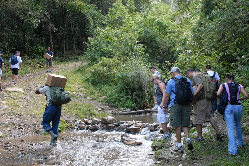 ALDEA BELLA VISTA, Honduras -- U.S. military personnel from Joint Task Force Bravo cross a stream here Oct. 20 as they begin their hike up Comayagua Mountain to deliver food to people in the village of Bella Vista.  The hike was organized by the JTF-Bravo chaplain to support local Hondurans.  Approximately 50 military members participated in the hike which was the second in a series of five planned to date.  (U.S. Air Force photo/1st Lt. Erika Yepsen)