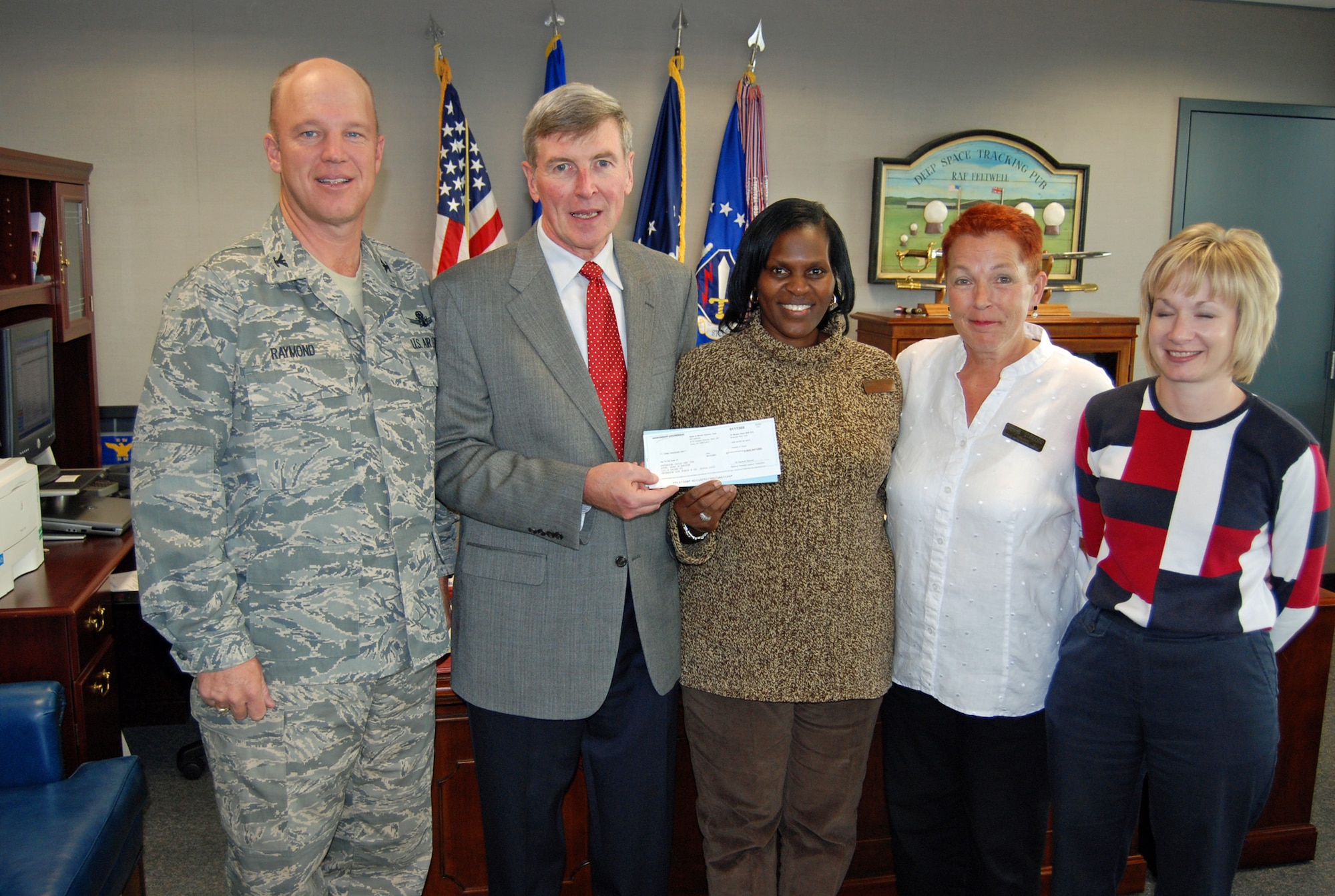 Tim McMahon, Northrop Grumman corporate lead executive for Colorado Springs, presents a $3,000 check to the Child Development Center Oct. 17 in the Wing commander’s office. Accepting the check are Col. Jay Raymond, 21st Space Wing commander, Ruby Belton, CDC director, Barbara Ziegler, CDC annex director, and Toni Hansen, Family Member Program flight chief. Mr. McMahon is a former 21st Operations Group commander. The donation, part of an educational grant, will be used to buy educational software at the CDC. (U.S. Air Force photo by Steve Brady)